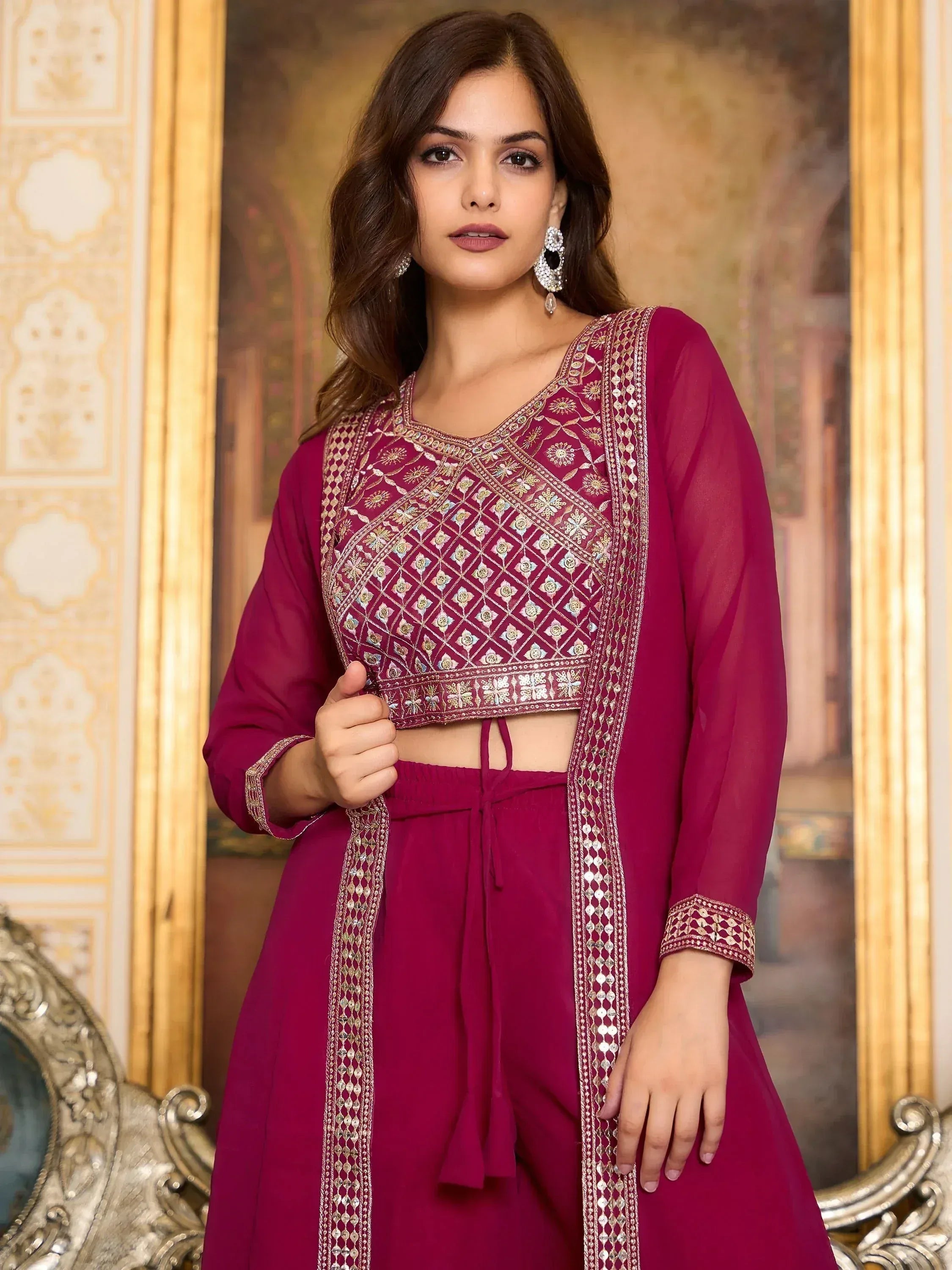 Woman wearing a maroon embroidered ethnic crop top and palazzo set with sheer dupatta
