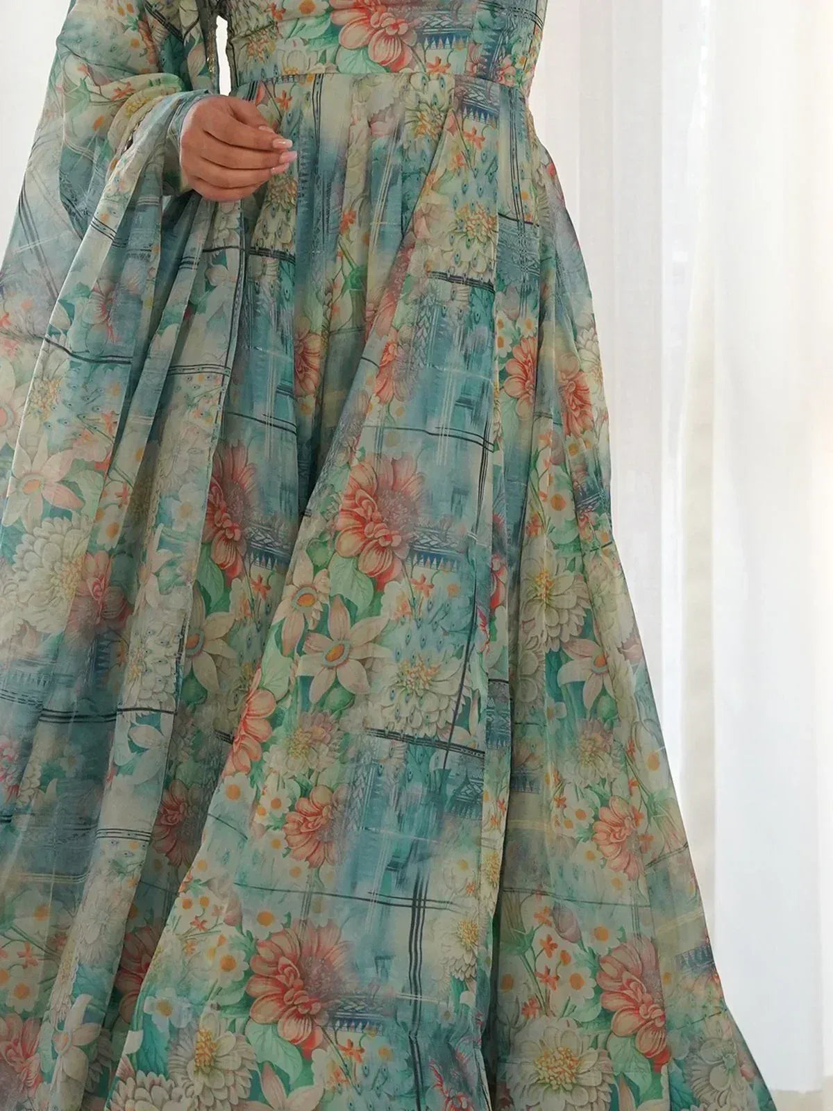 Floral print ethnic gown with pastel hues and architectural motifs, perfect for Indian festive occasions.