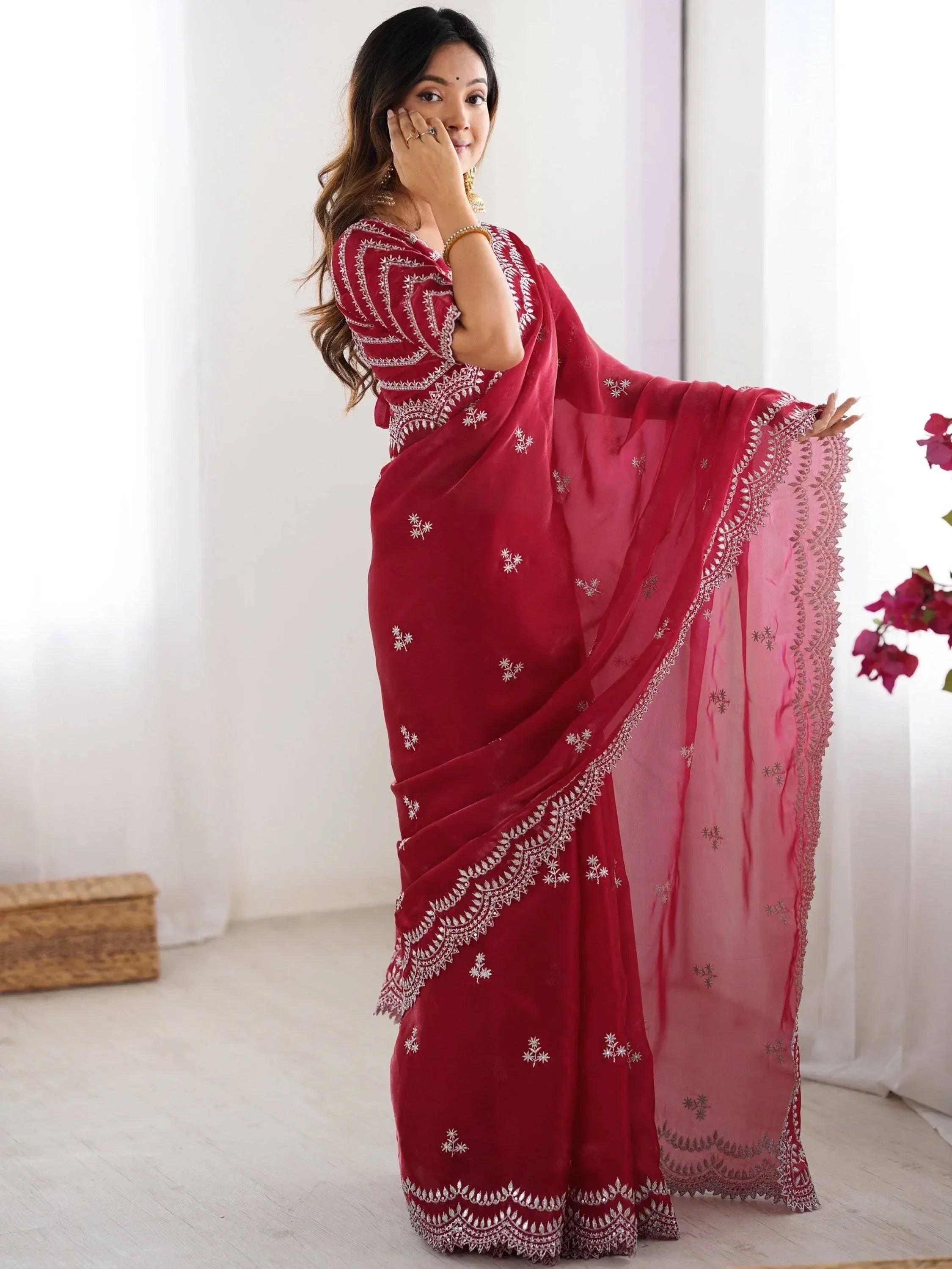 Woman in red embroidered saree with white floral motifs, elegant Indian ethnic wear for festive occasions