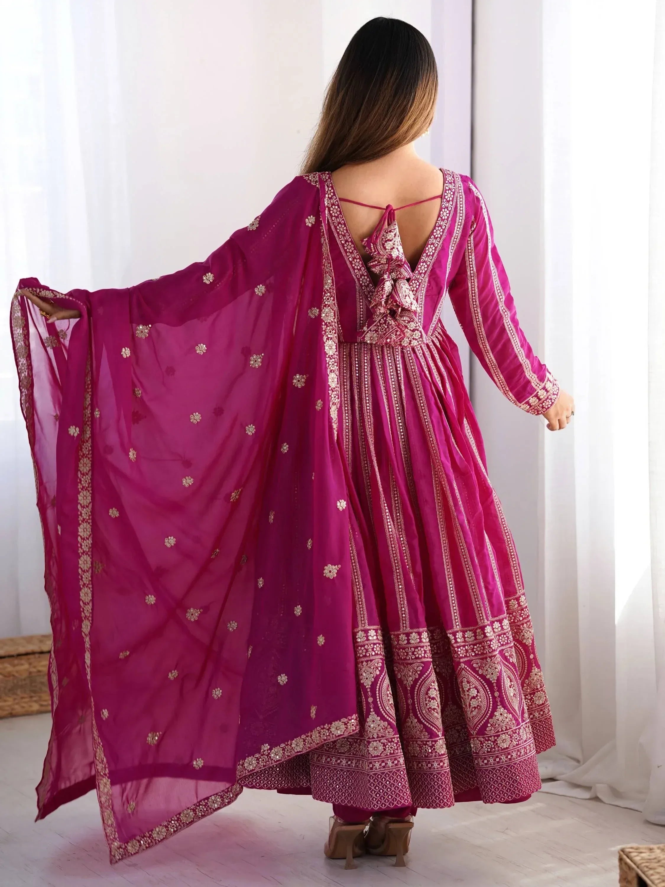 Fuchsia ethnic anarkali suit with gold embroidery and sheer dupatta, back view