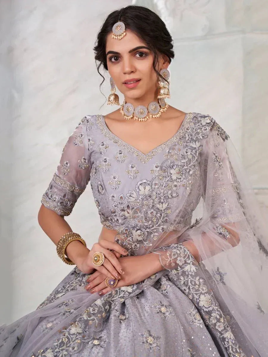 Elegant grey embroidered lehenga choli with floral detailing and sheer sleeves, perfect for Indian ethnic occasions