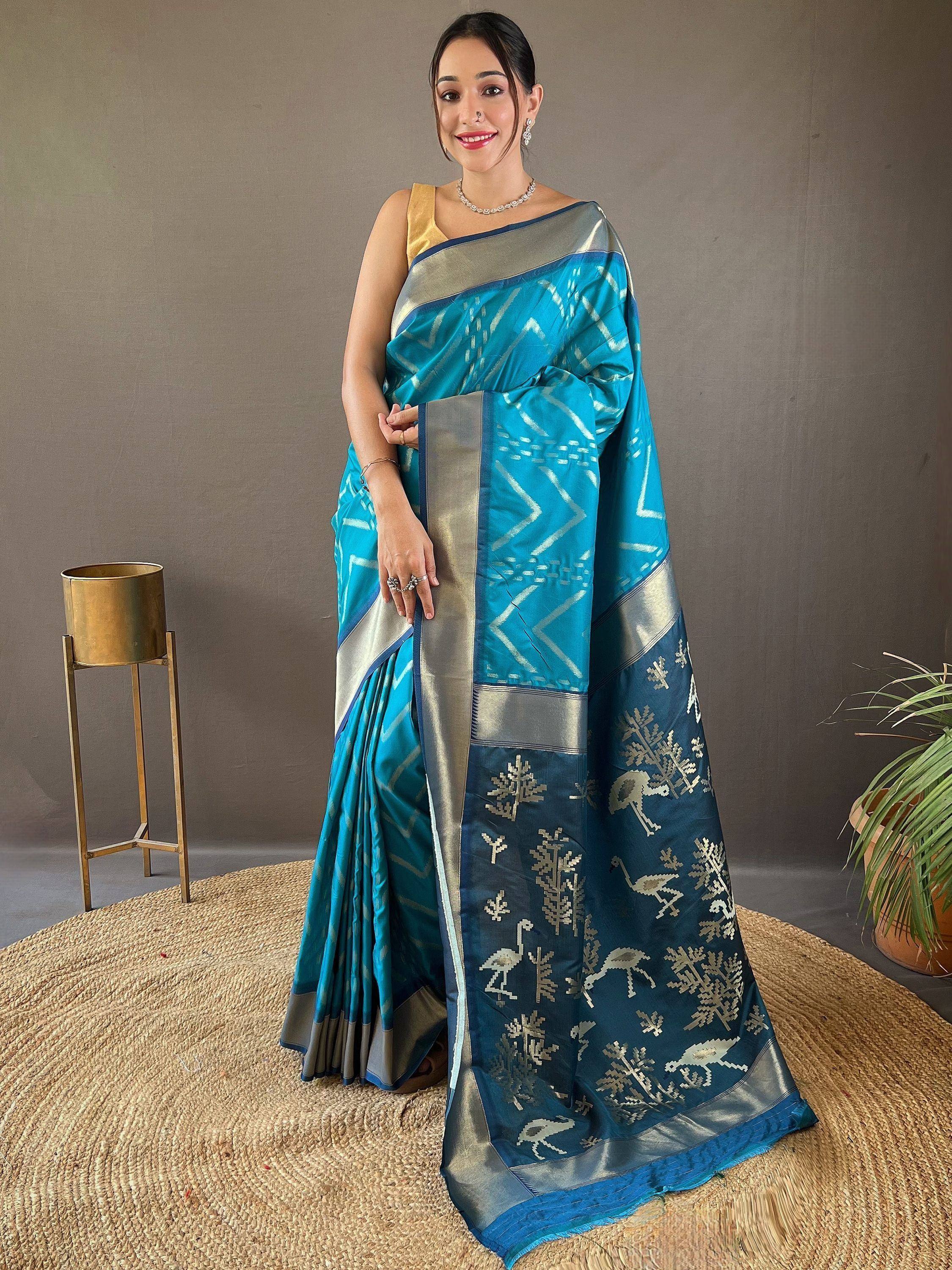 Woman in blue ikat saree with silver border and bird motifs, paired with gold blouse, ethnic wear
