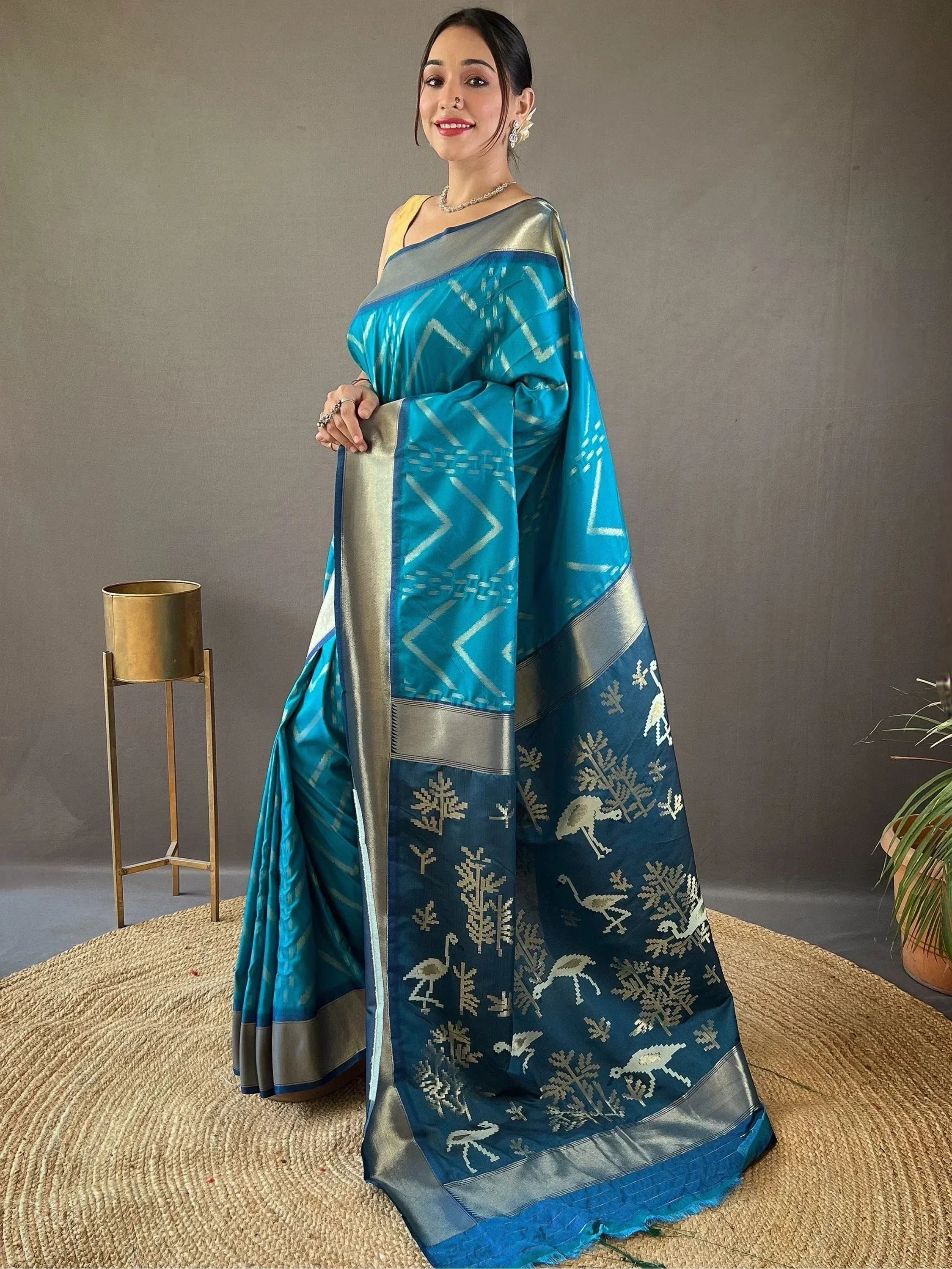 Woman in blue and silver ethnic saree with bird and tree motifs, perfect for Indian occasions