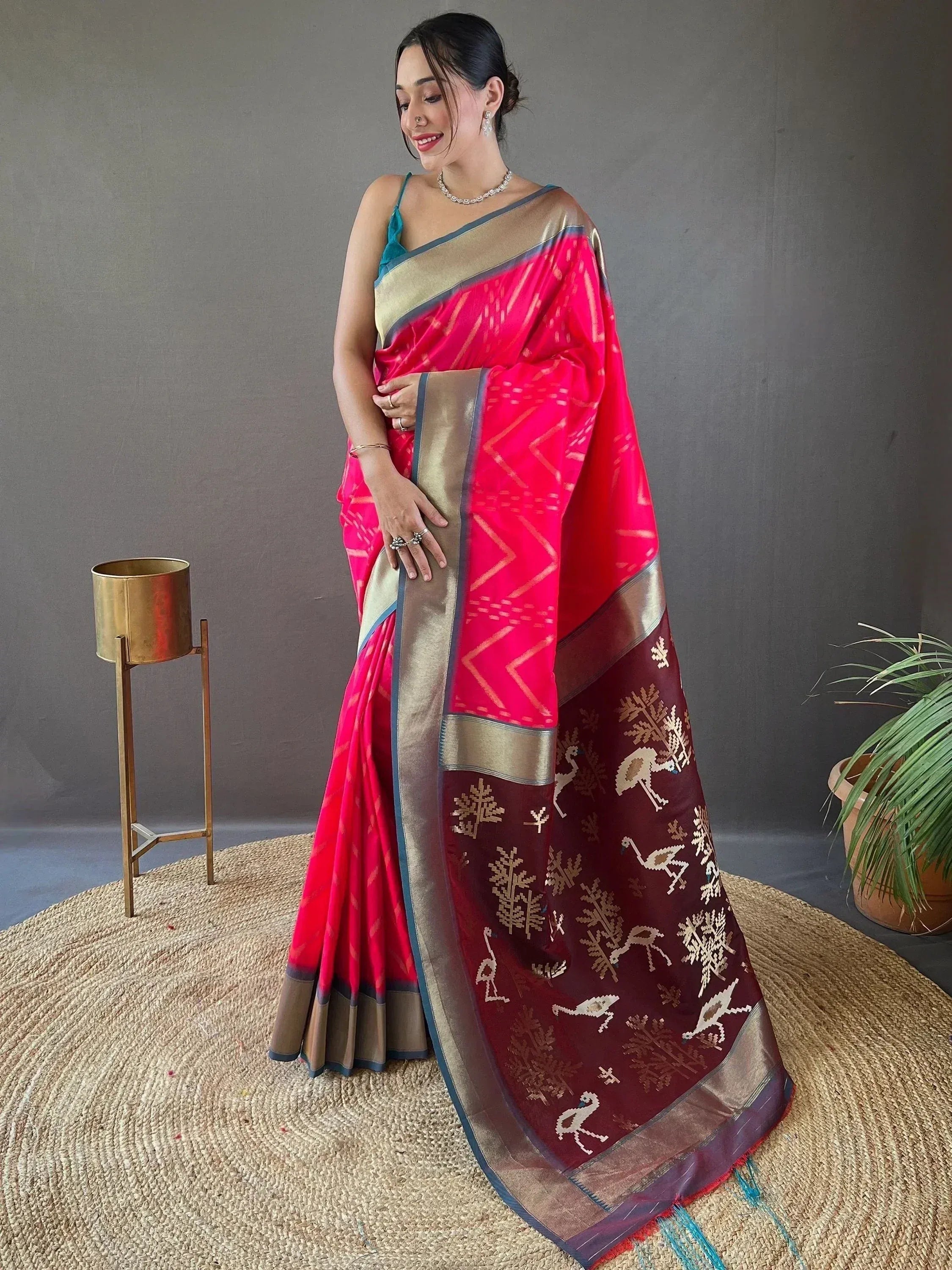 Woman in vibrant pink and maroon ethnic saree with gold bird and tree motifs, perfect for Indian occasions.