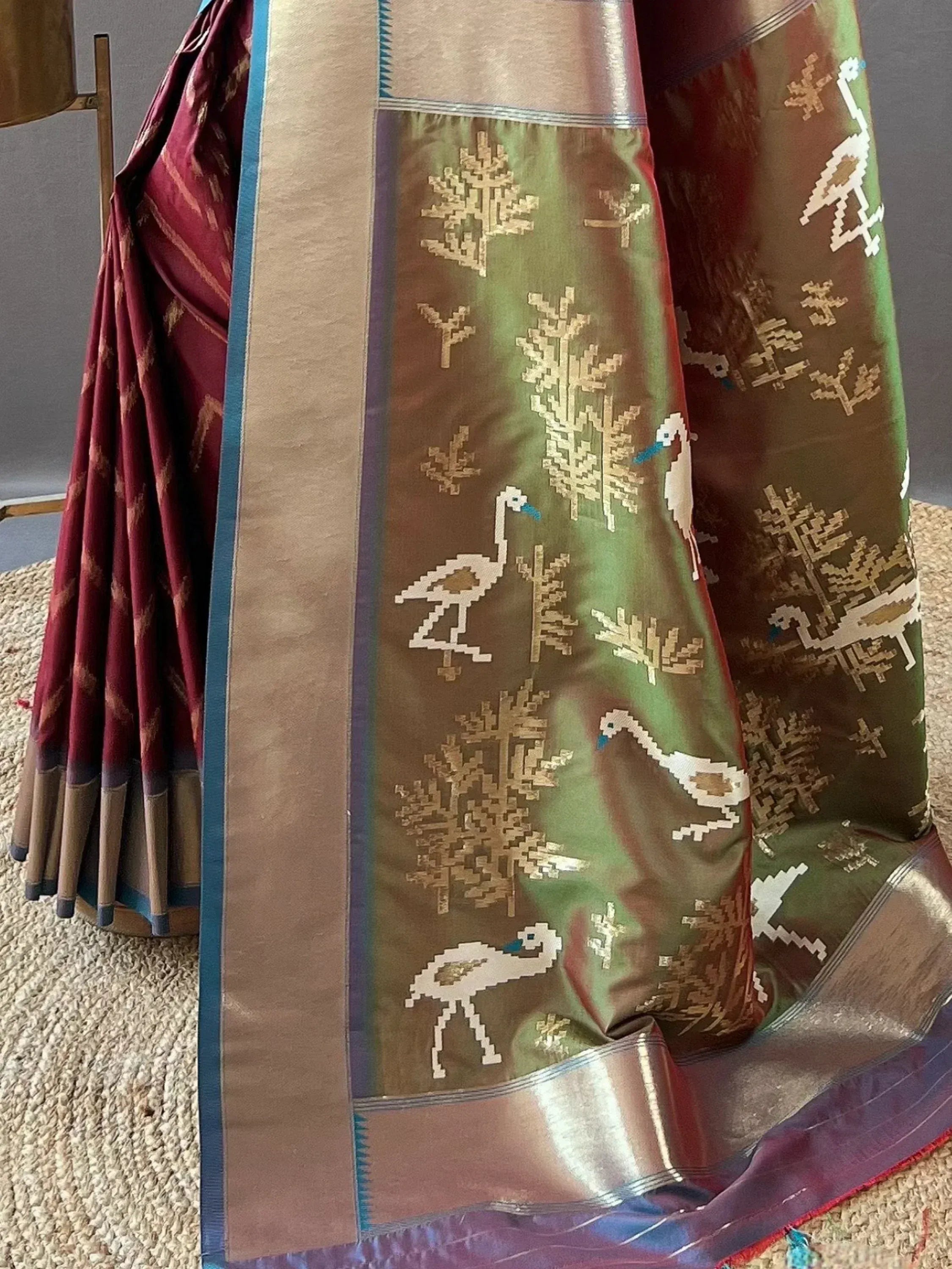Elegant Indian saree with bird and tree motifs, rich maroon and green hues, perfect for ethnic wear occasions.