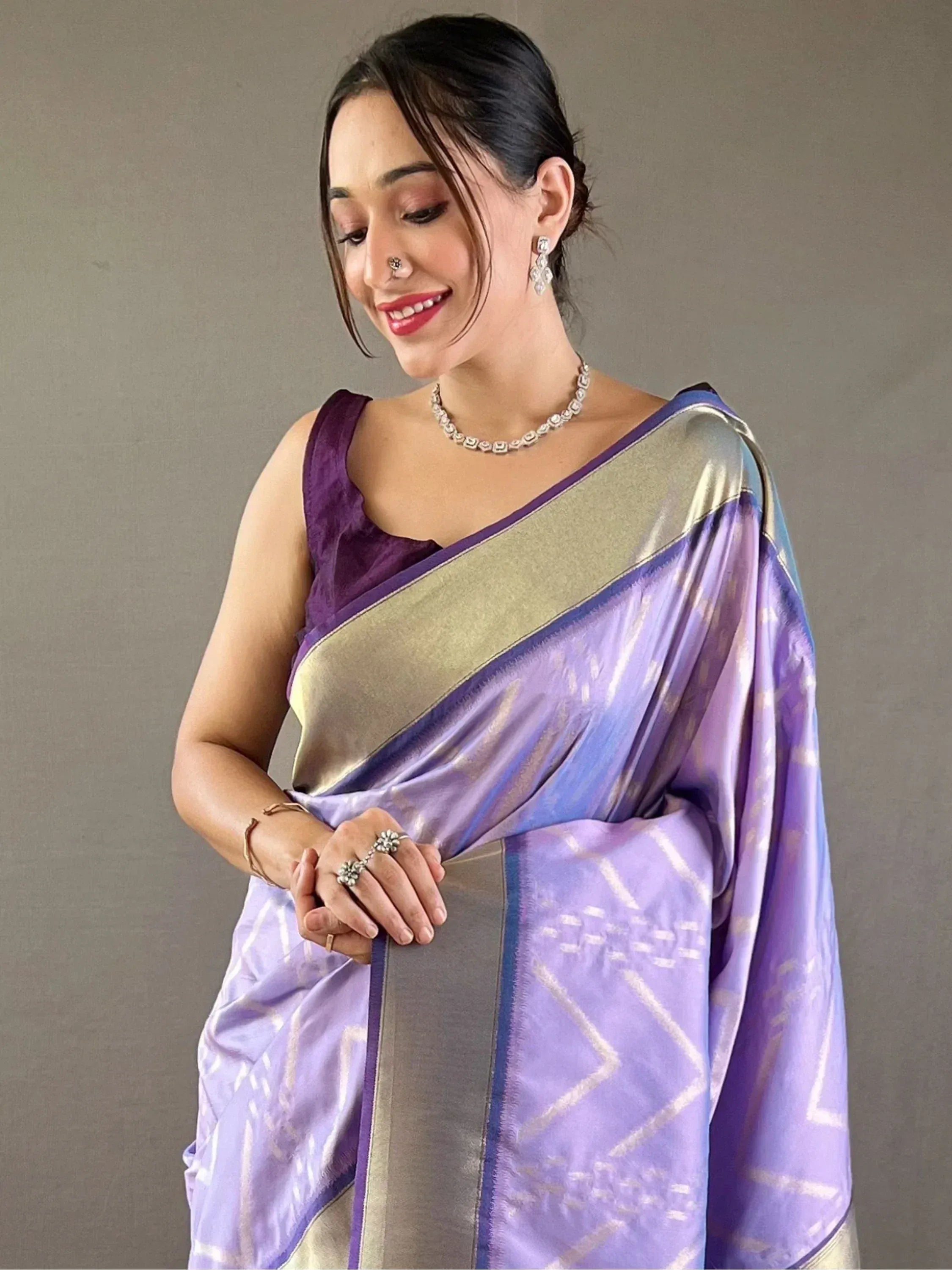 Purple and gold designer saree with geometric patterns, paired with elegant jewelry for ethnic wear