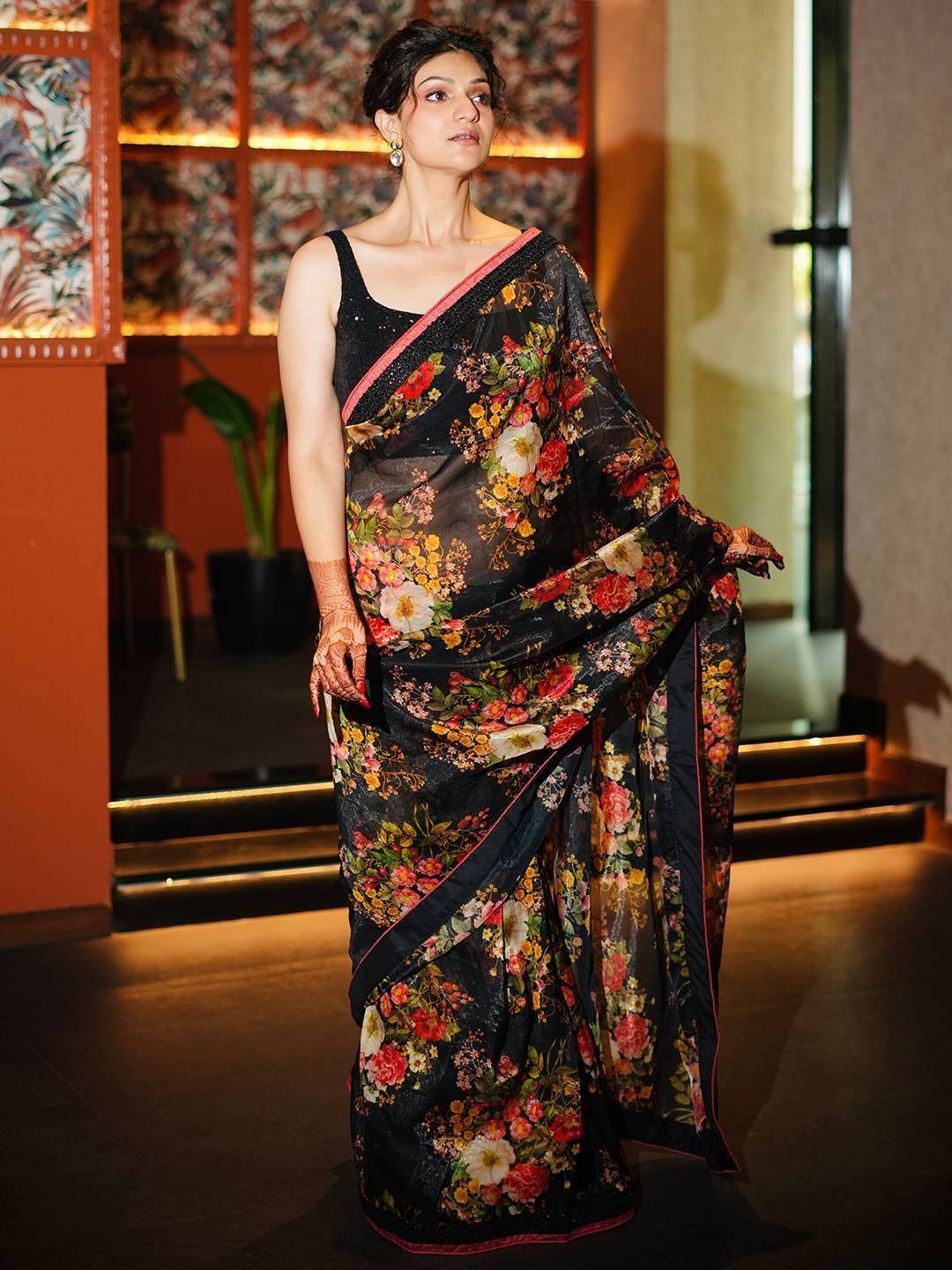 Black floral print saree with pink border, styled with black blouse for ethnic wear