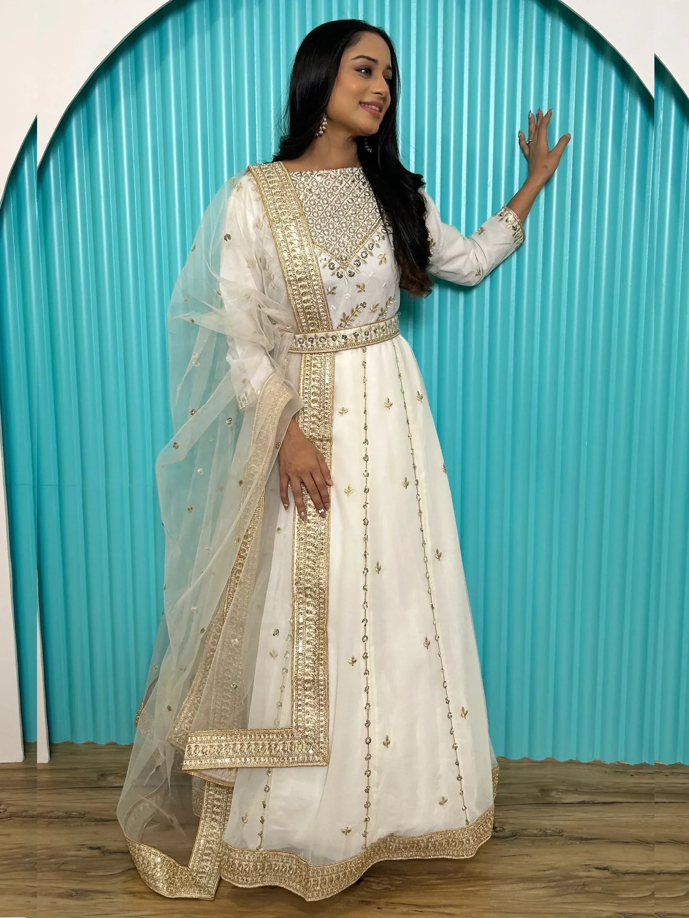 White ethnic gown with gold embroidery and sheer dupatta, perfect for Indian occasions