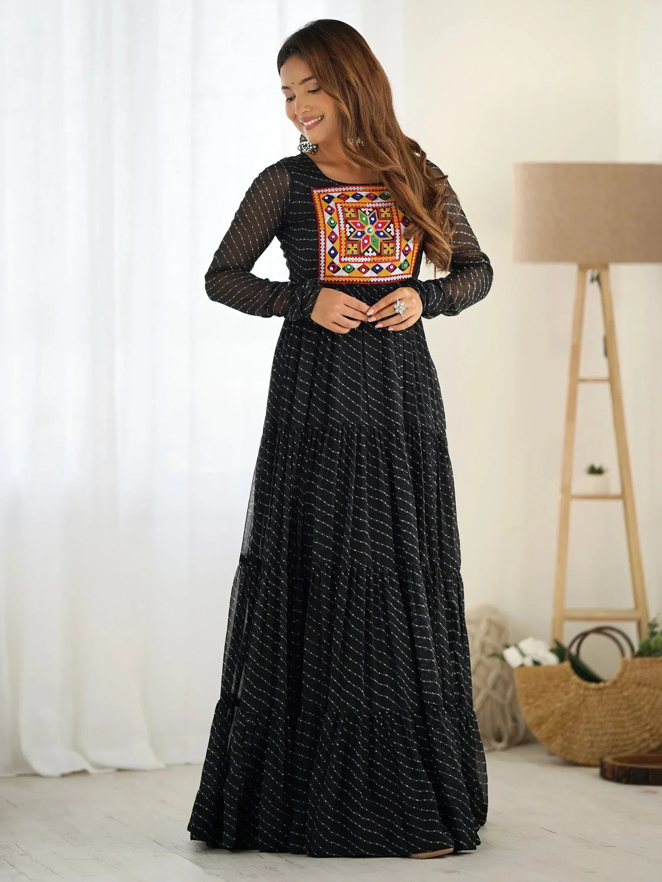 Woman in a black ethnic gown with colorful embroidered yoke and sheer long sleeves