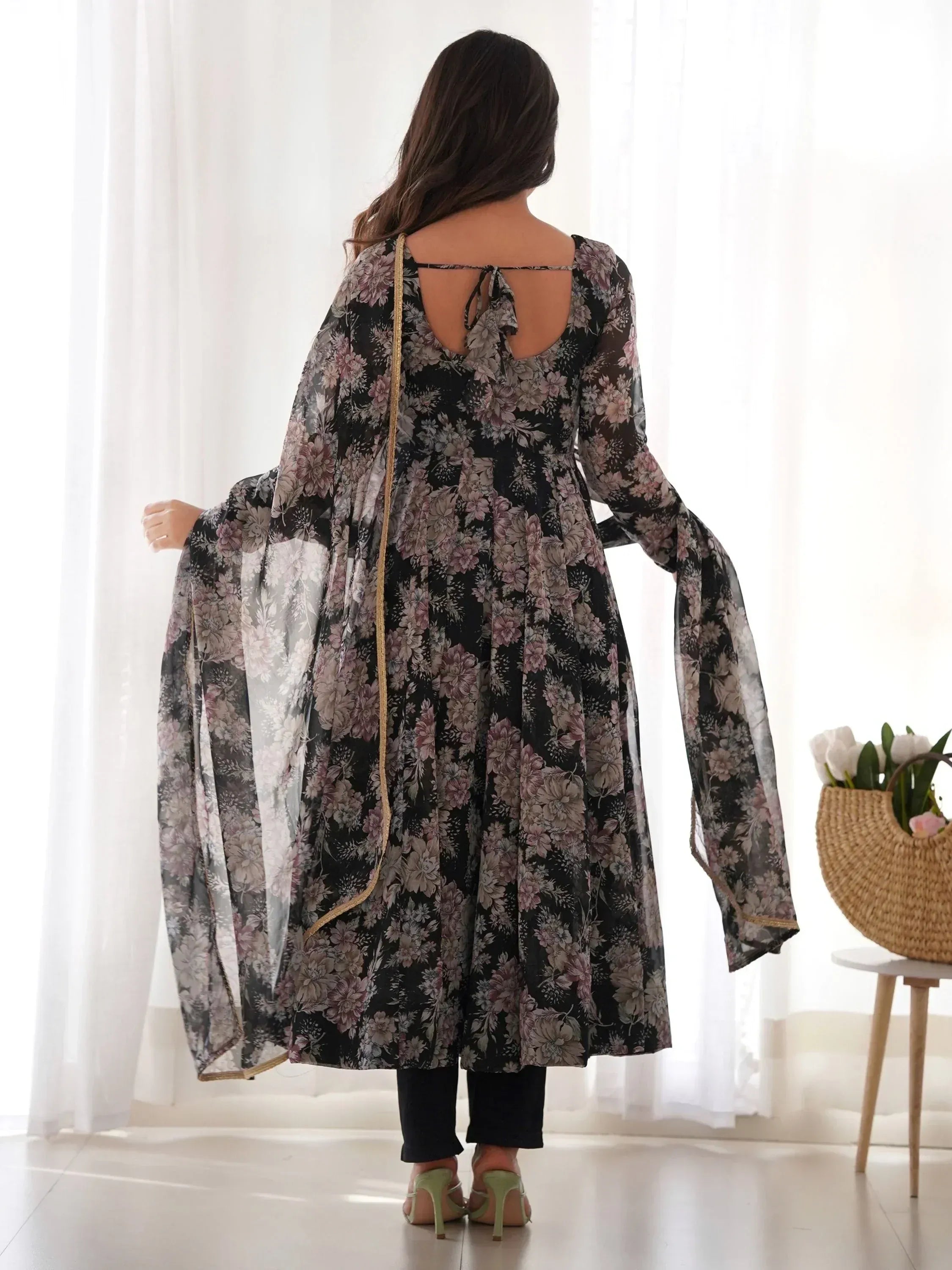 Floral print ethnic gown with sheer sleeves and back tie, paired with black pants and green heels.