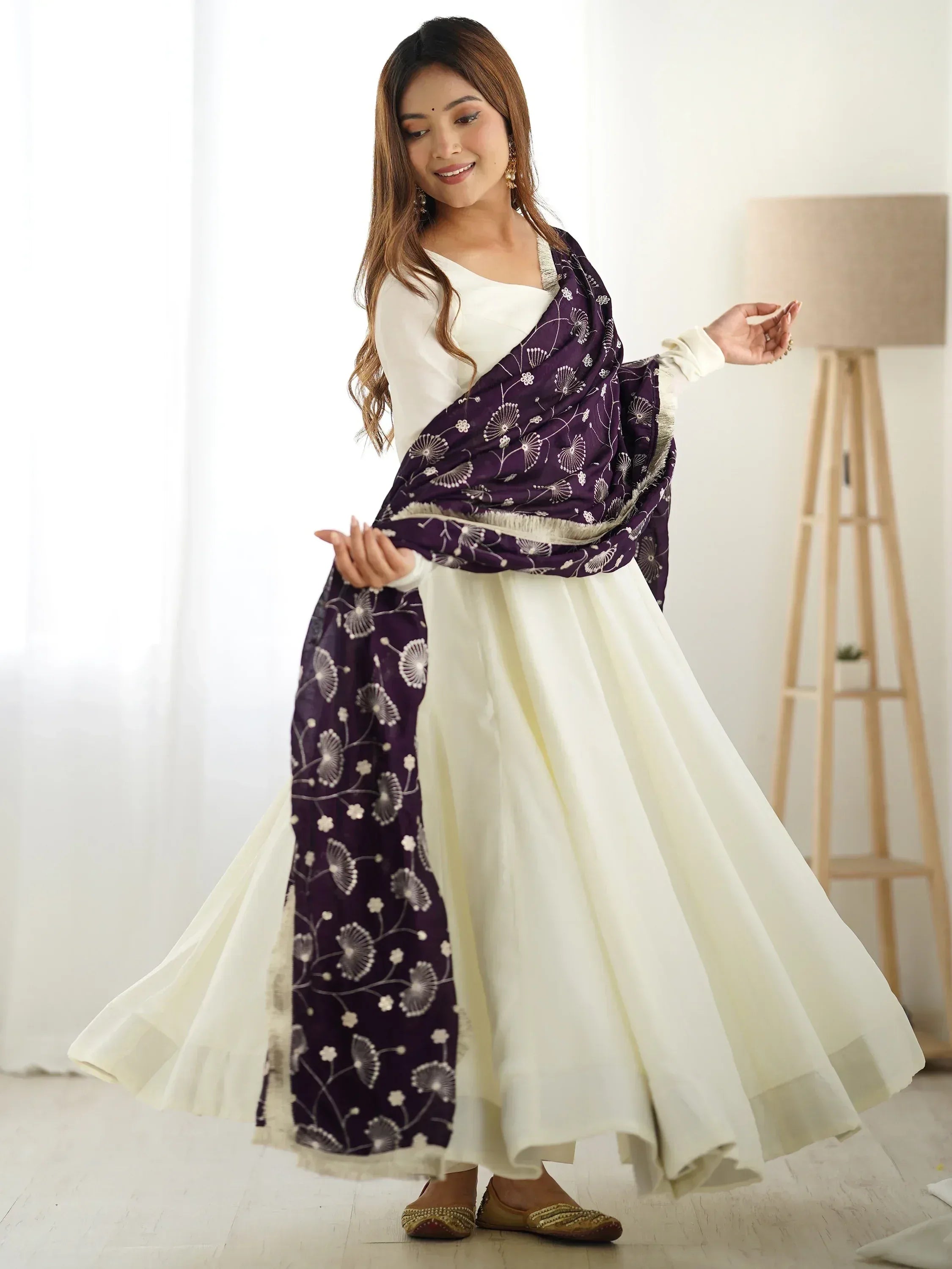 Woman in white ethnic gown with purple floral dupatta, Indian designer wear for festive occasions