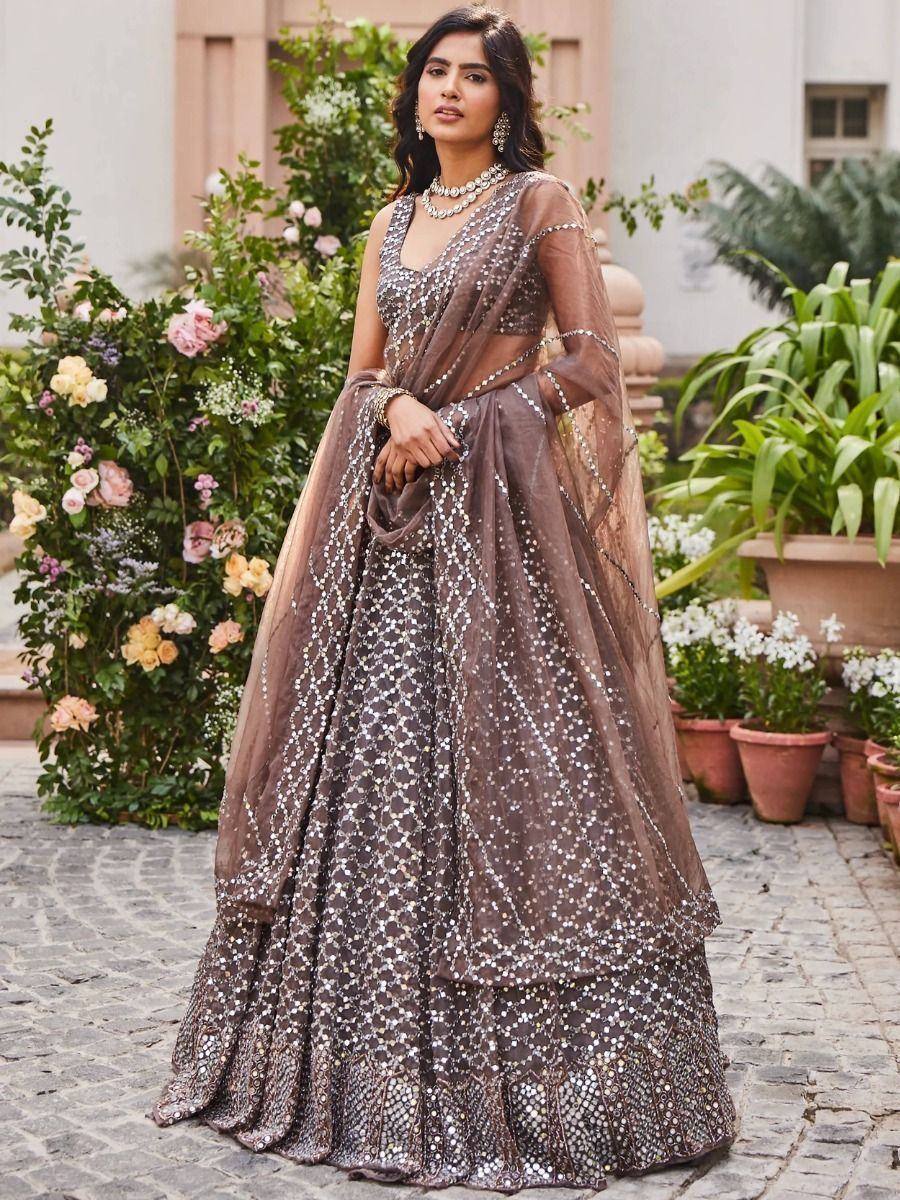 Elegant brown mirror-work lehenga choli with sheer dupatta, perfect for Indian weddings and festive occasions