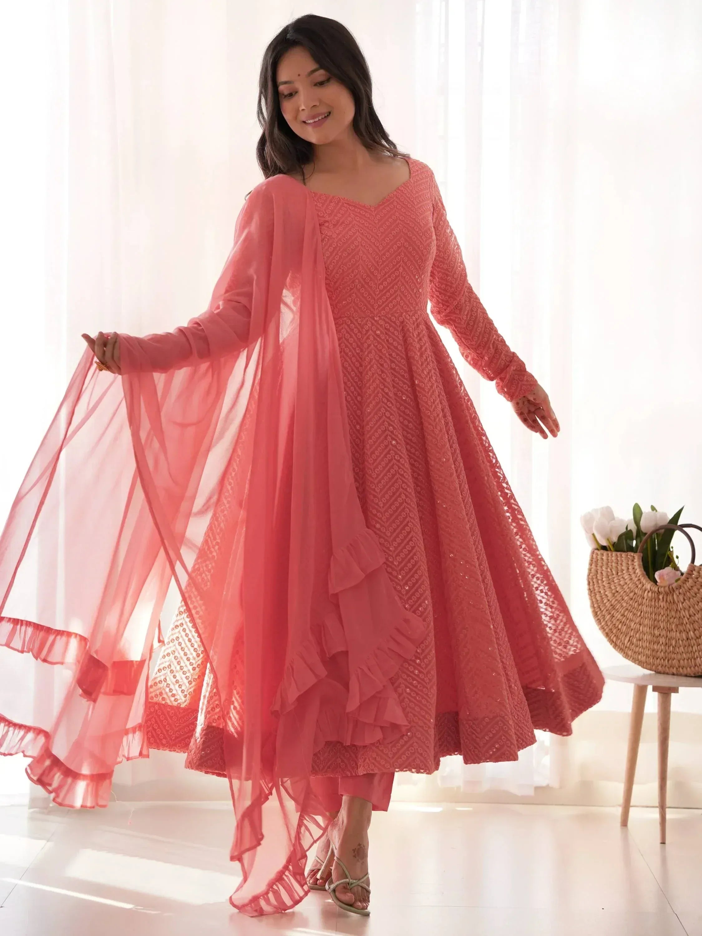 Elegant coral ethnic gown with ruffled dupatta, perfect for Indian festive occasions