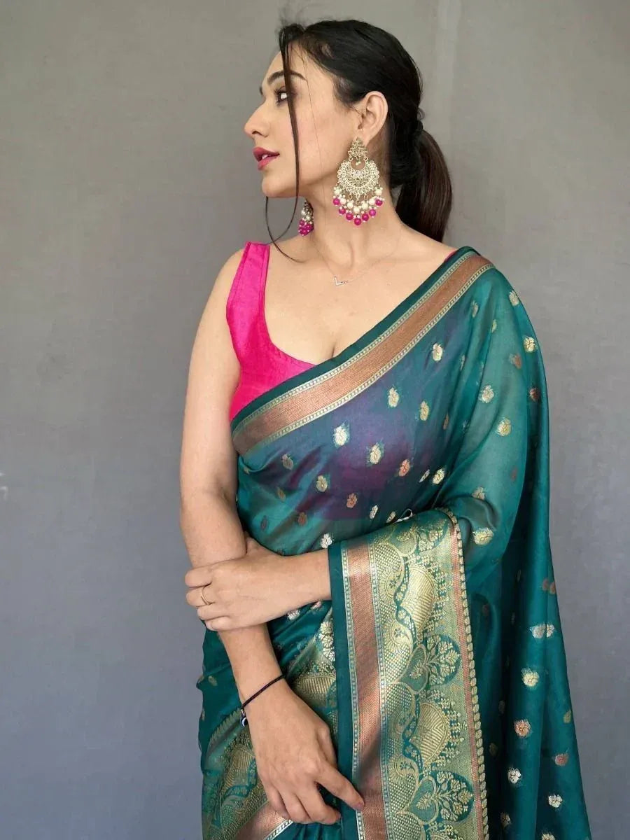 Teal designer saree with gold motifs and pink blouse, styled with statement earrings for ethnic wear