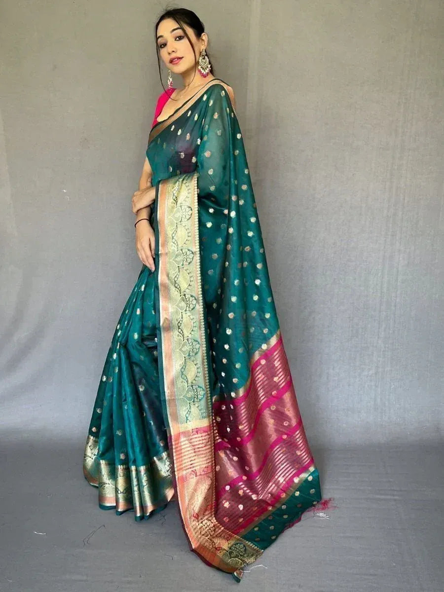 Teal silk saree with gold motifs and pink border, styled with pink blouse for ethnic wear
