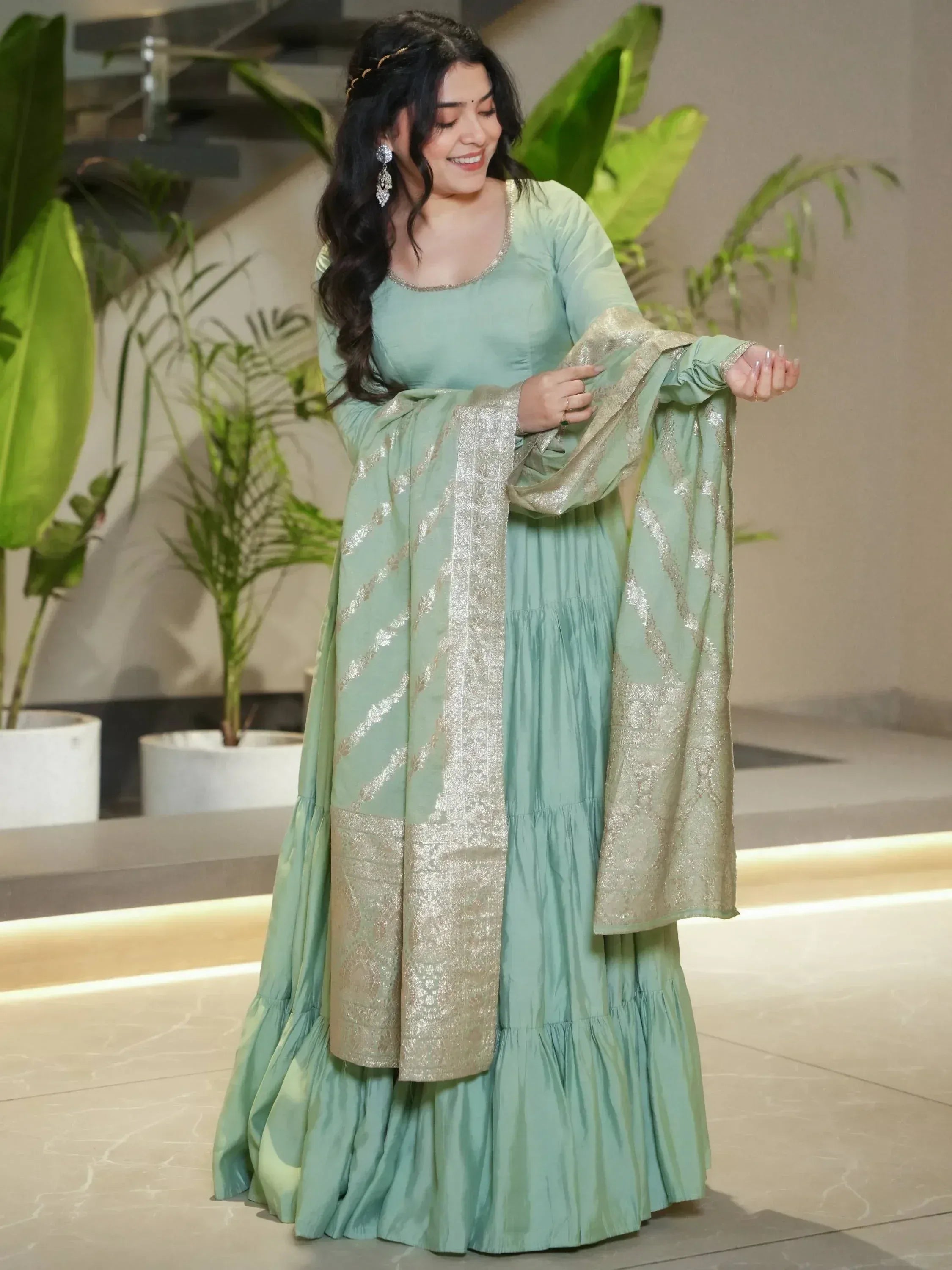 Mint green ethnic gown with gold embroidery, perfect for Indian occasions and festive wear.