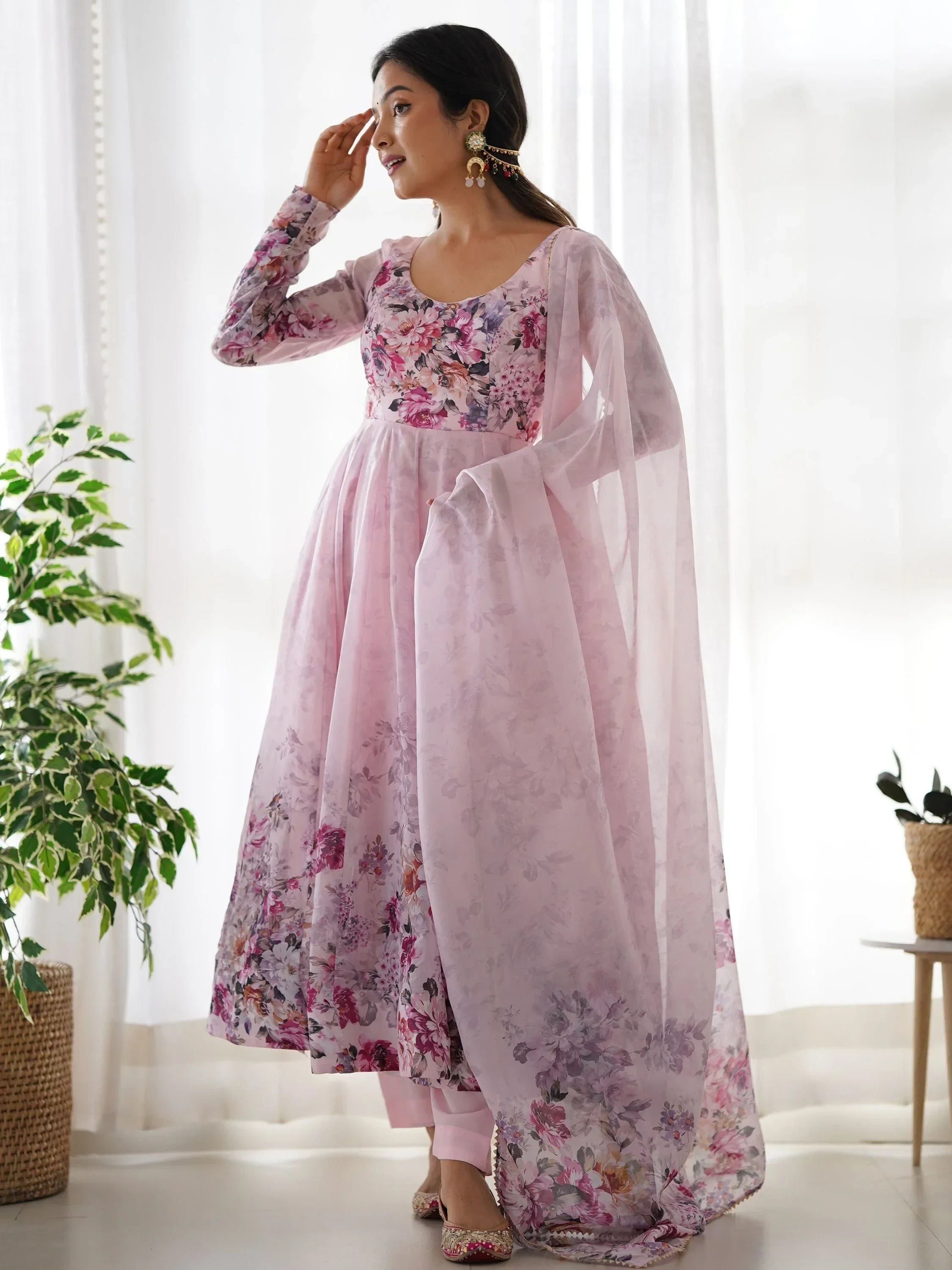 Woman in pink floral Anarkali suit with sheer dupatta, traditional Indian ethnic wear