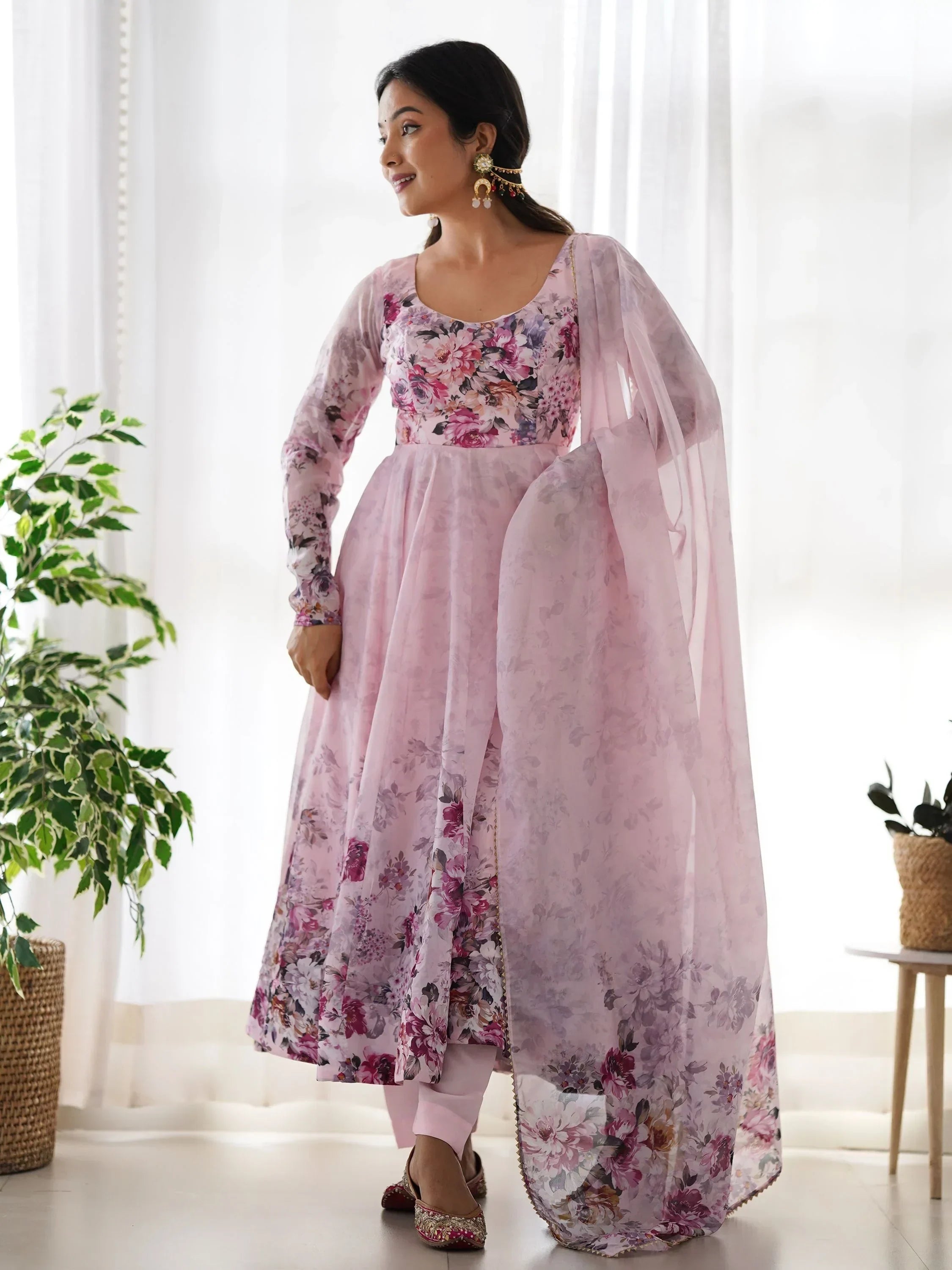Woman wearing pastel pink floral Anarkali suit with matching dupatta, traditional Indian ethnic wear