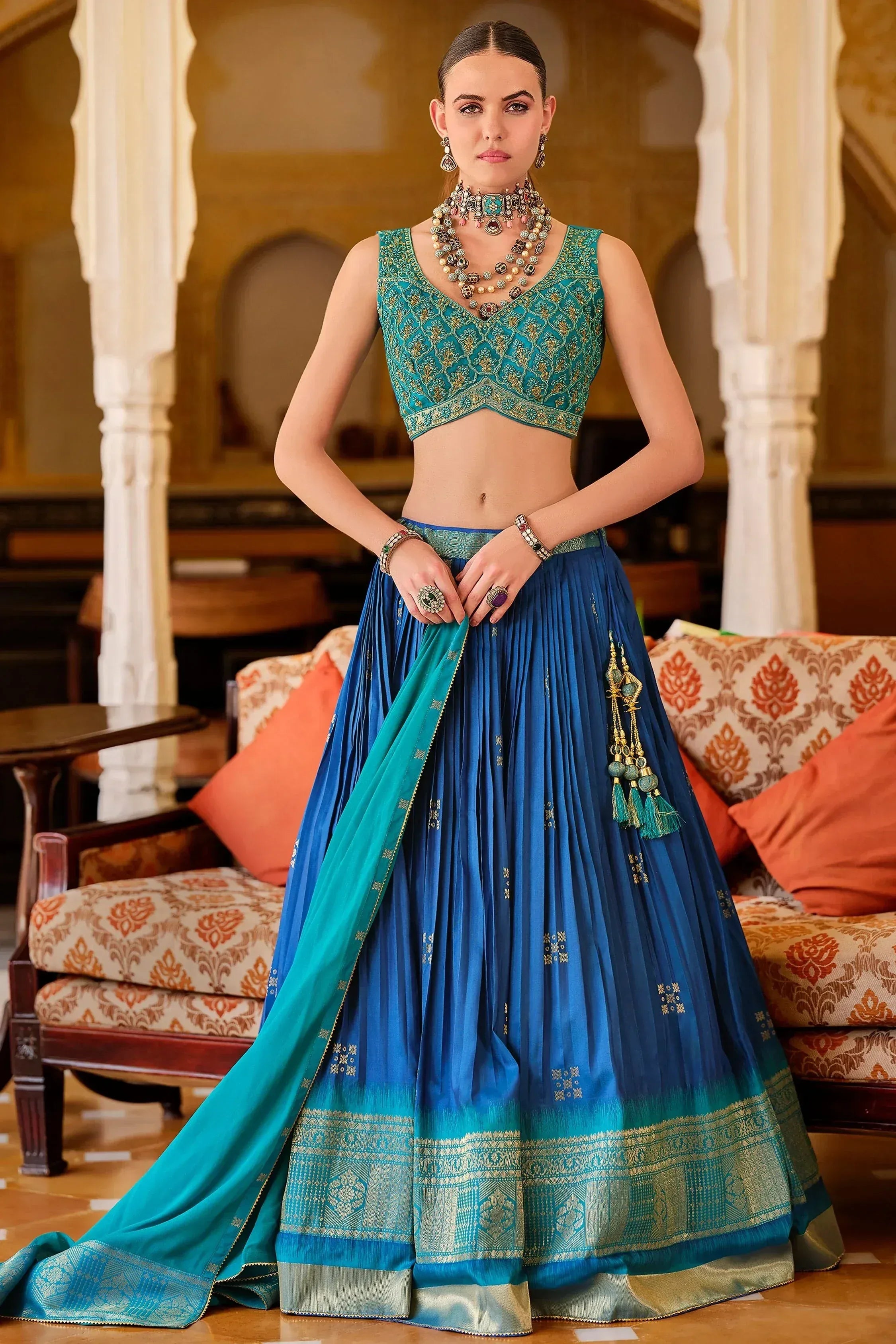 Teal and blue designer lehenga choli with gold embroidery, perfect for Indian ethnic wear occasions.