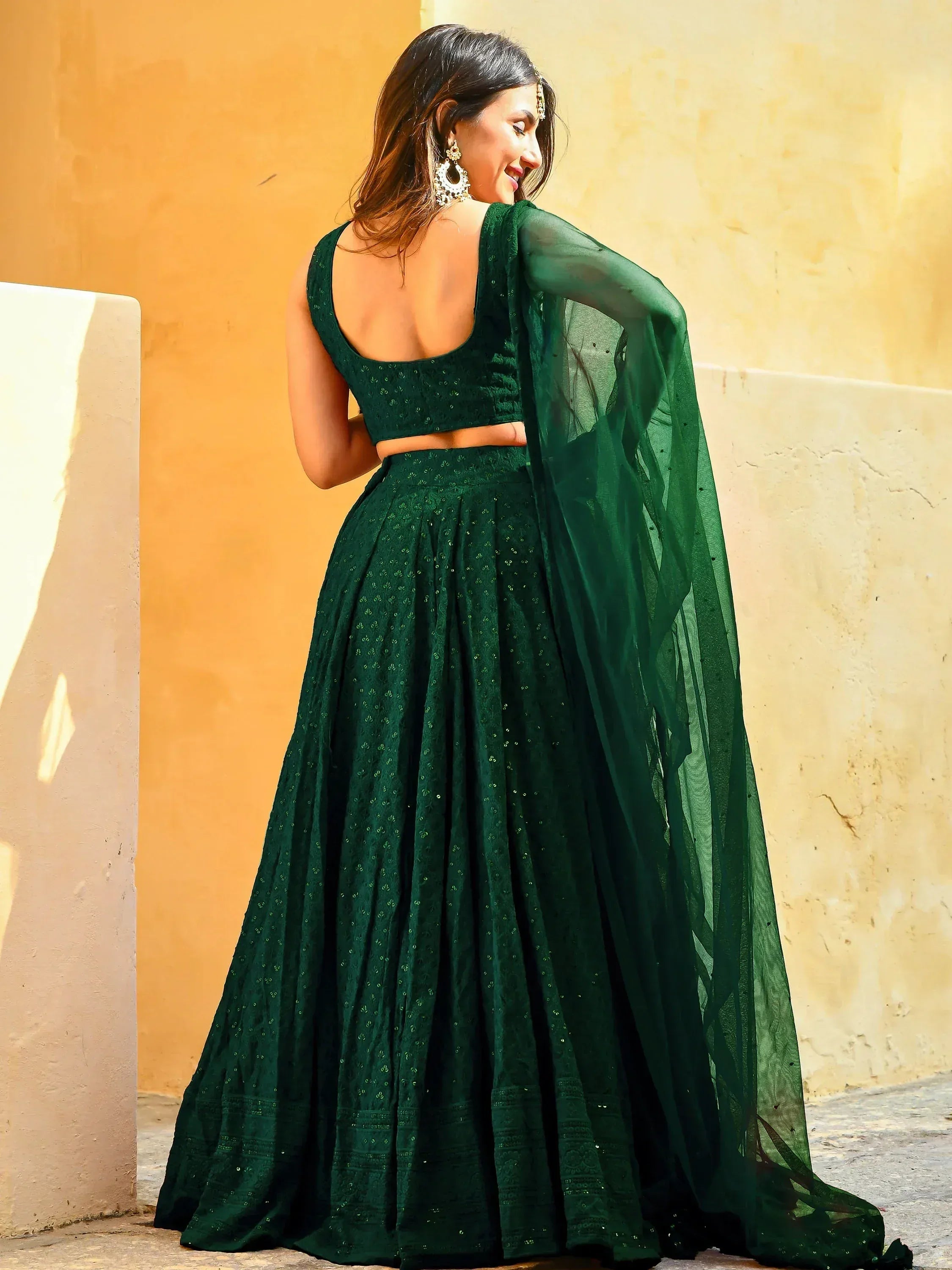 Emerald green designer lehenga choli with sheer dupatta, perfect for Indian ethnic wear occasions.