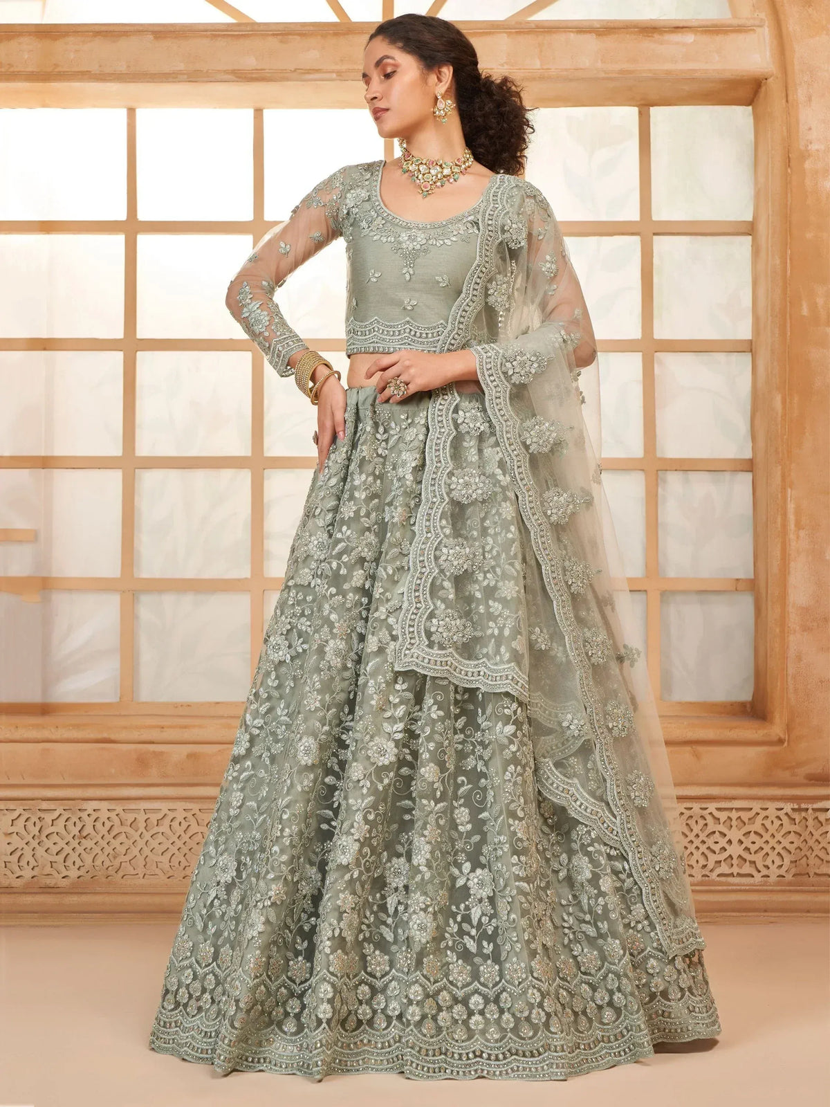 Elegant sage green designer lehenga choli with intricate floral embroidery and sheer dupatta for Indian ethnic wear.