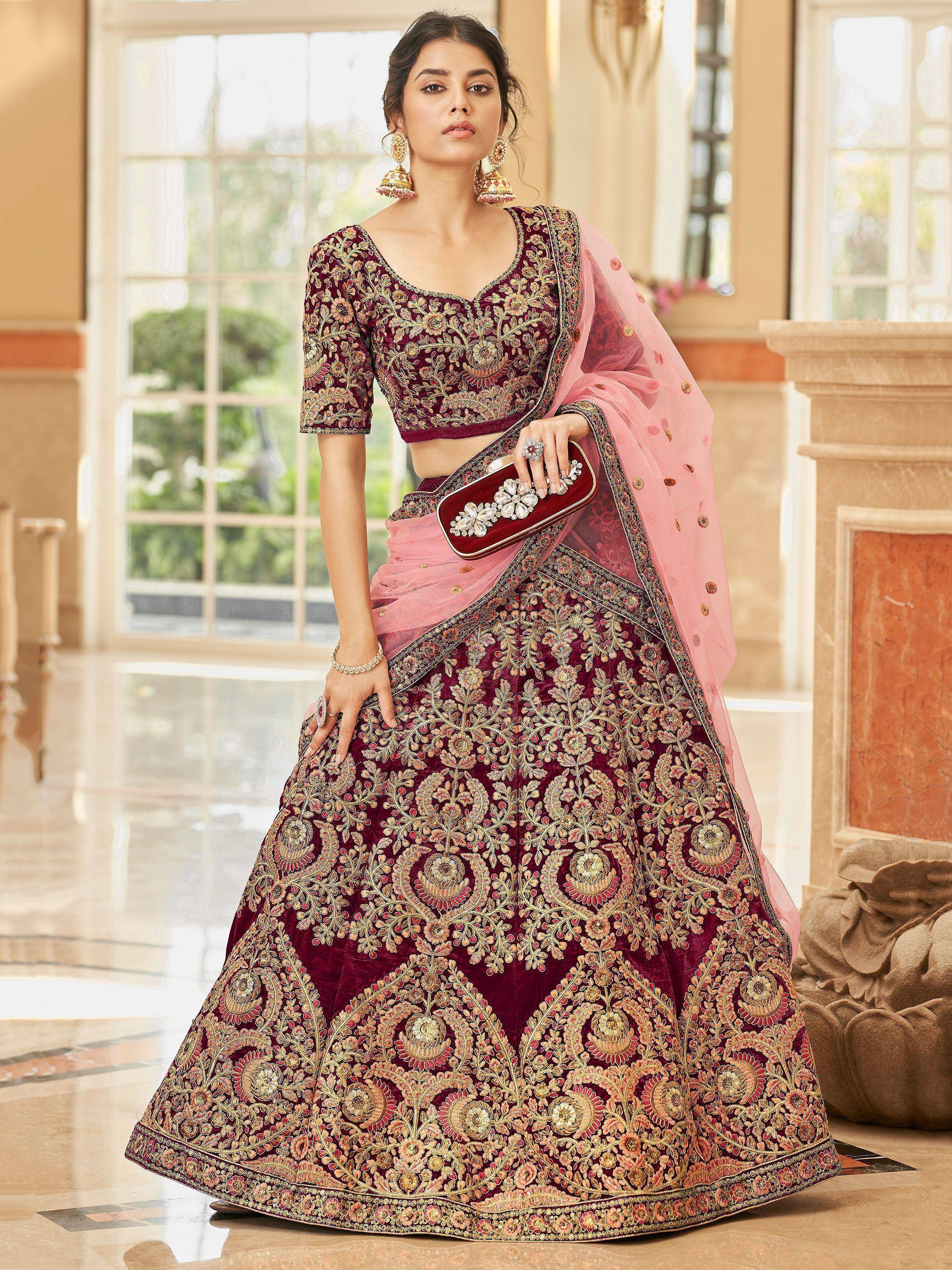 Maroon velvet lehenga choli with gold embroidery, pink dupatta, perfect for weddings and festive occasions.