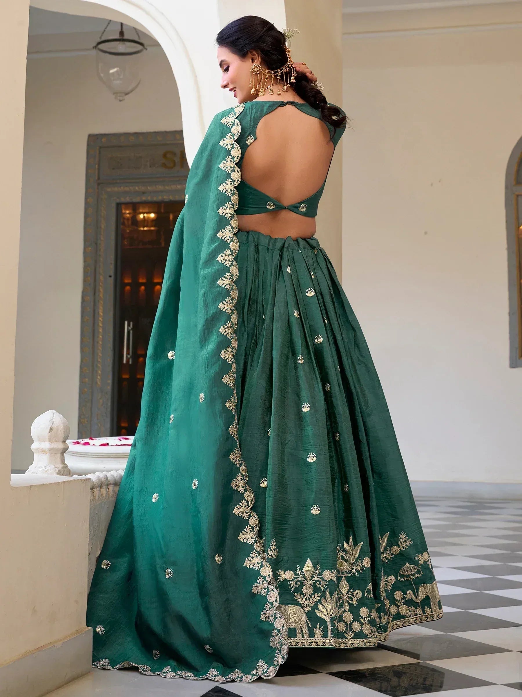 Emerald green lehenga choli with gold embroidery, backless blouse, and elephant motifs for Indian ethnic wear