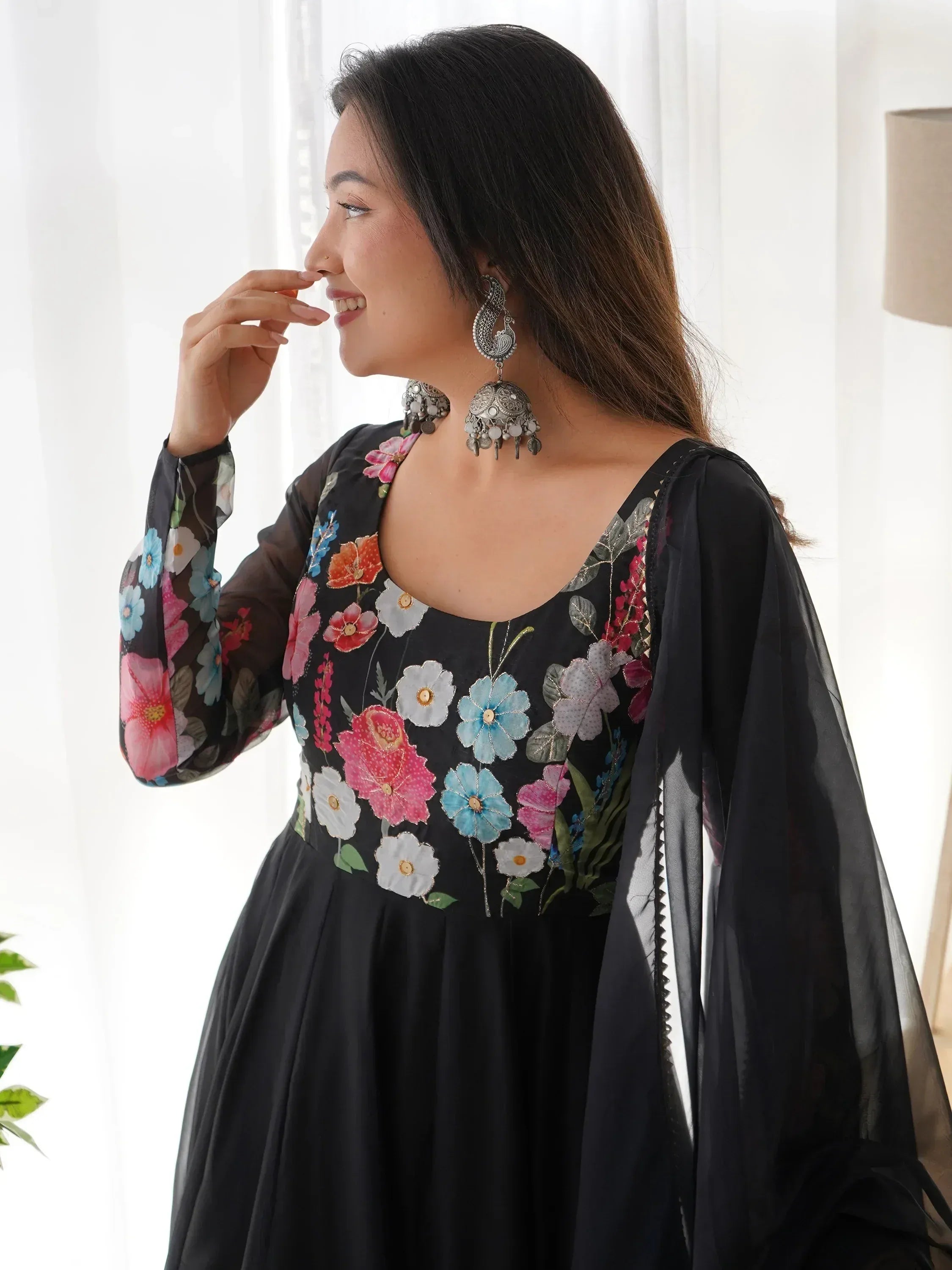 Black floral embroidered ethnic gown with sheer sleeves and traditional jewelry