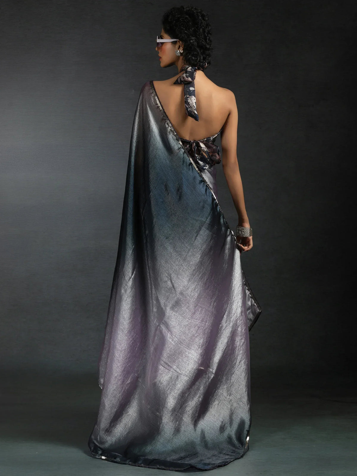 Shimmering metallic saree with backless halter neck design, perfect for ethnic occasions