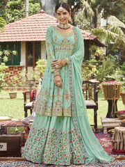 Woman in pastel green embroidered lehenga choli with dupatta, Indian ethnic wear, outdoor setting