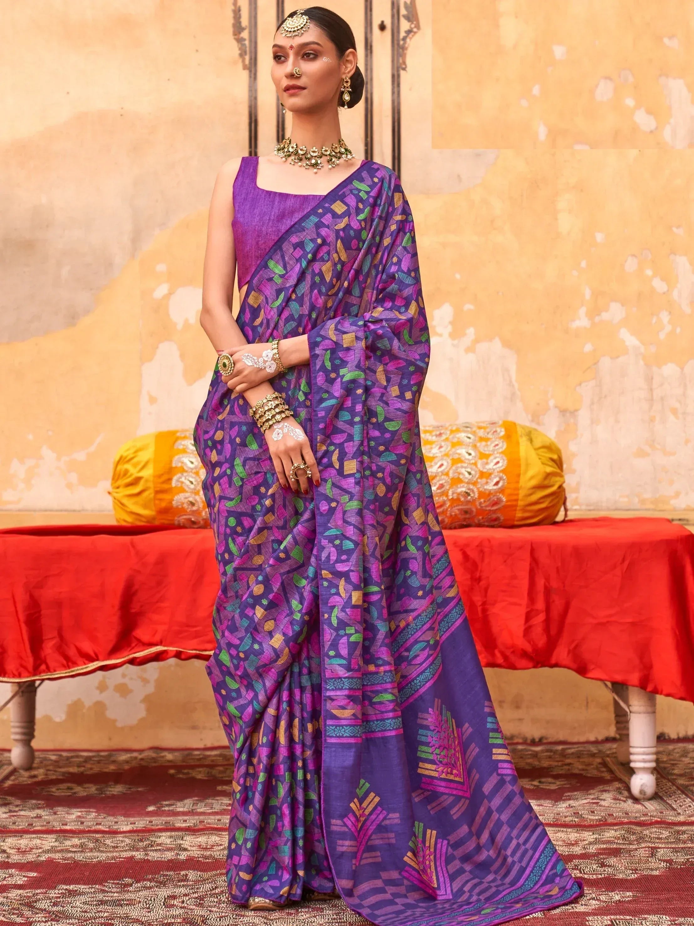 Purple printed saree with geometric patterns, paired with matching blouse and traditional jewelry for ethnic wear