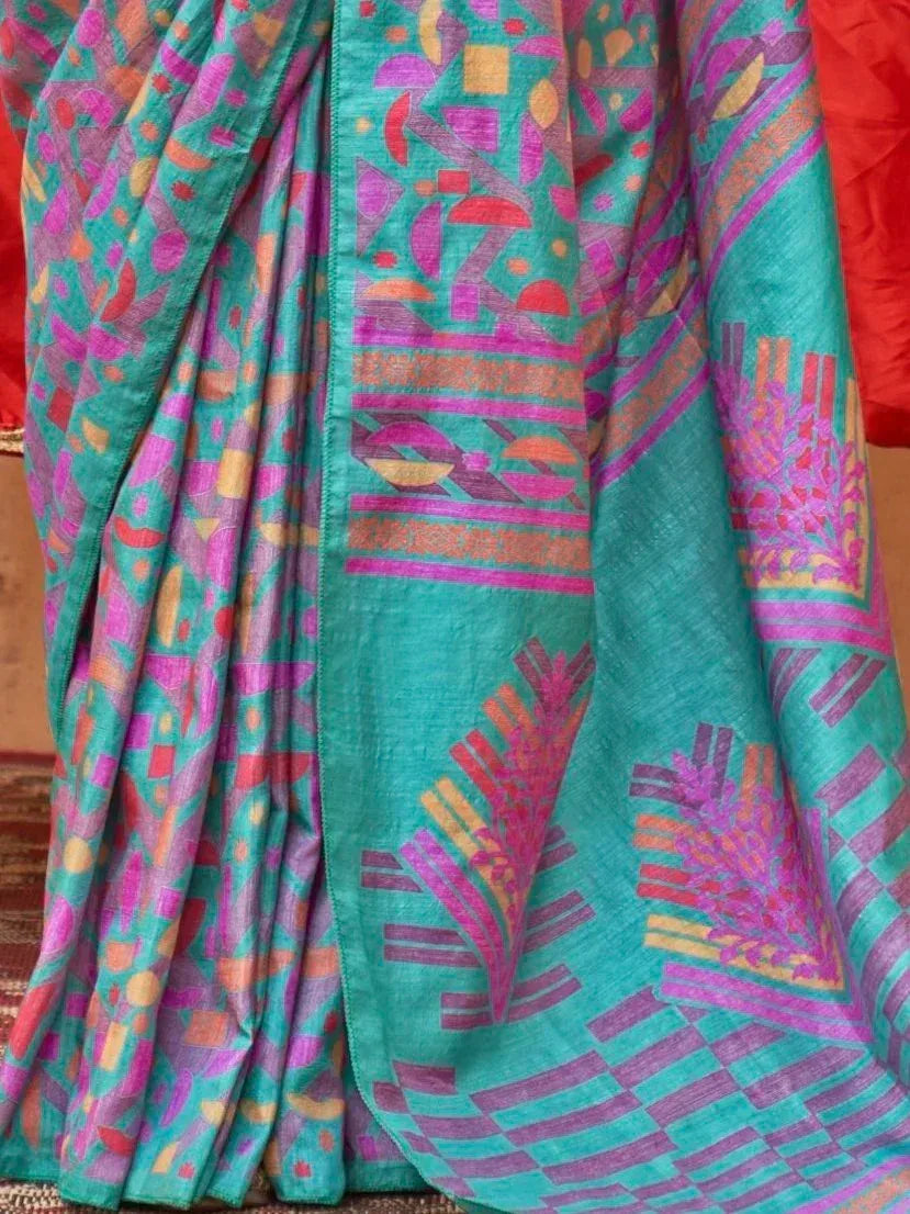 Teal saree with vibrant geometric print in pink, orange, and purple, perfect for ethnic wear occasions.