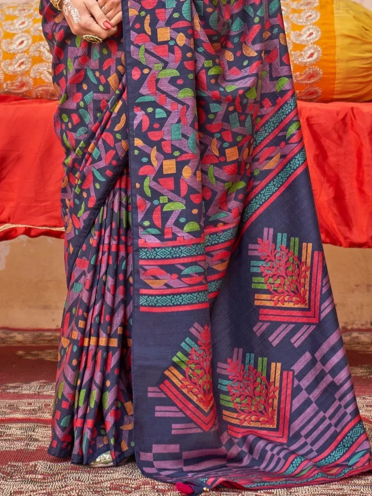 Vibrant geometric print saree in navy with red, green, and purple motifs, styled for ethnic wear.