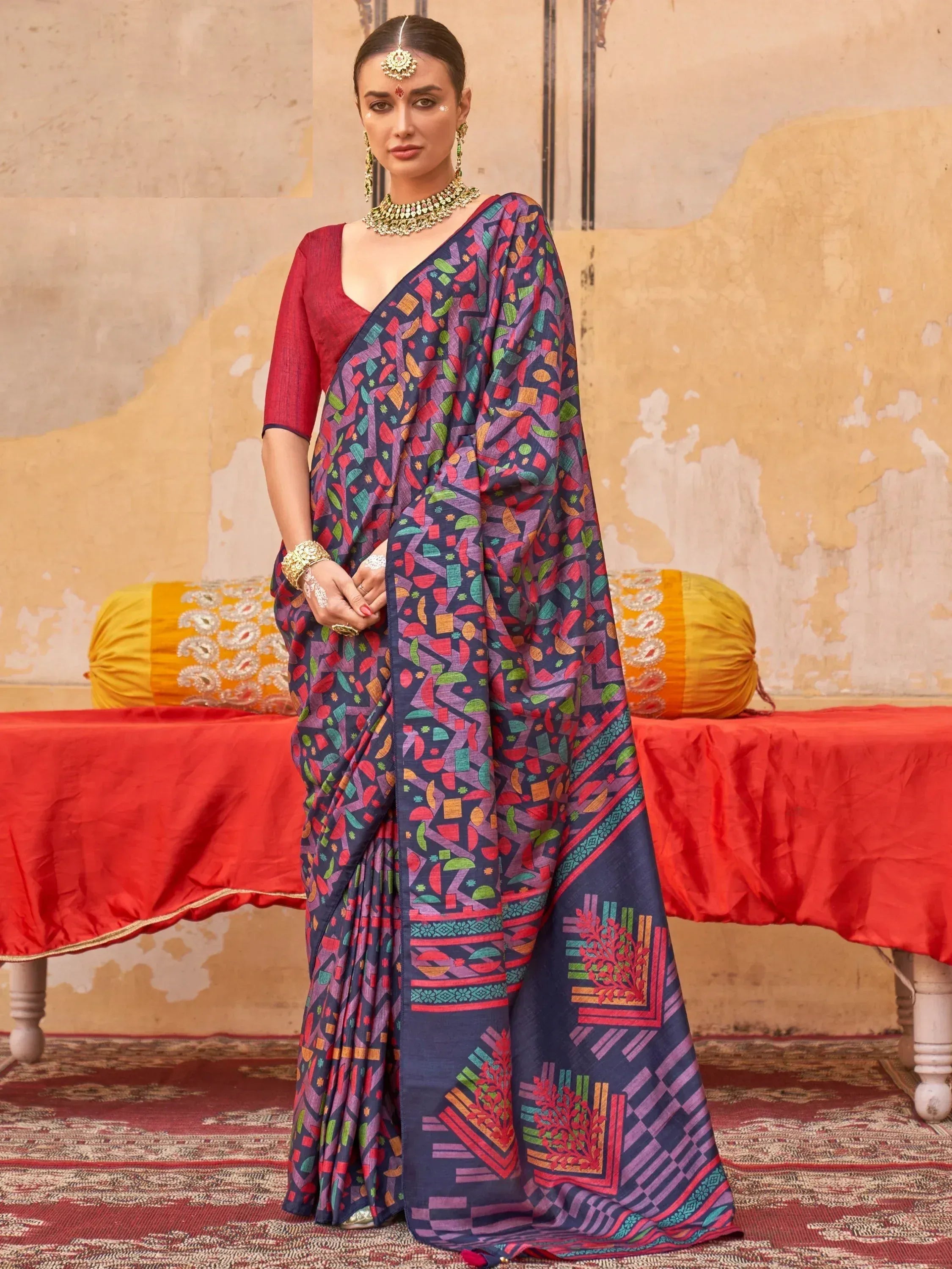 Woman in colorful printed saree with geometric patterns, red blouse, traditional Indian jewelry, ethnic wear