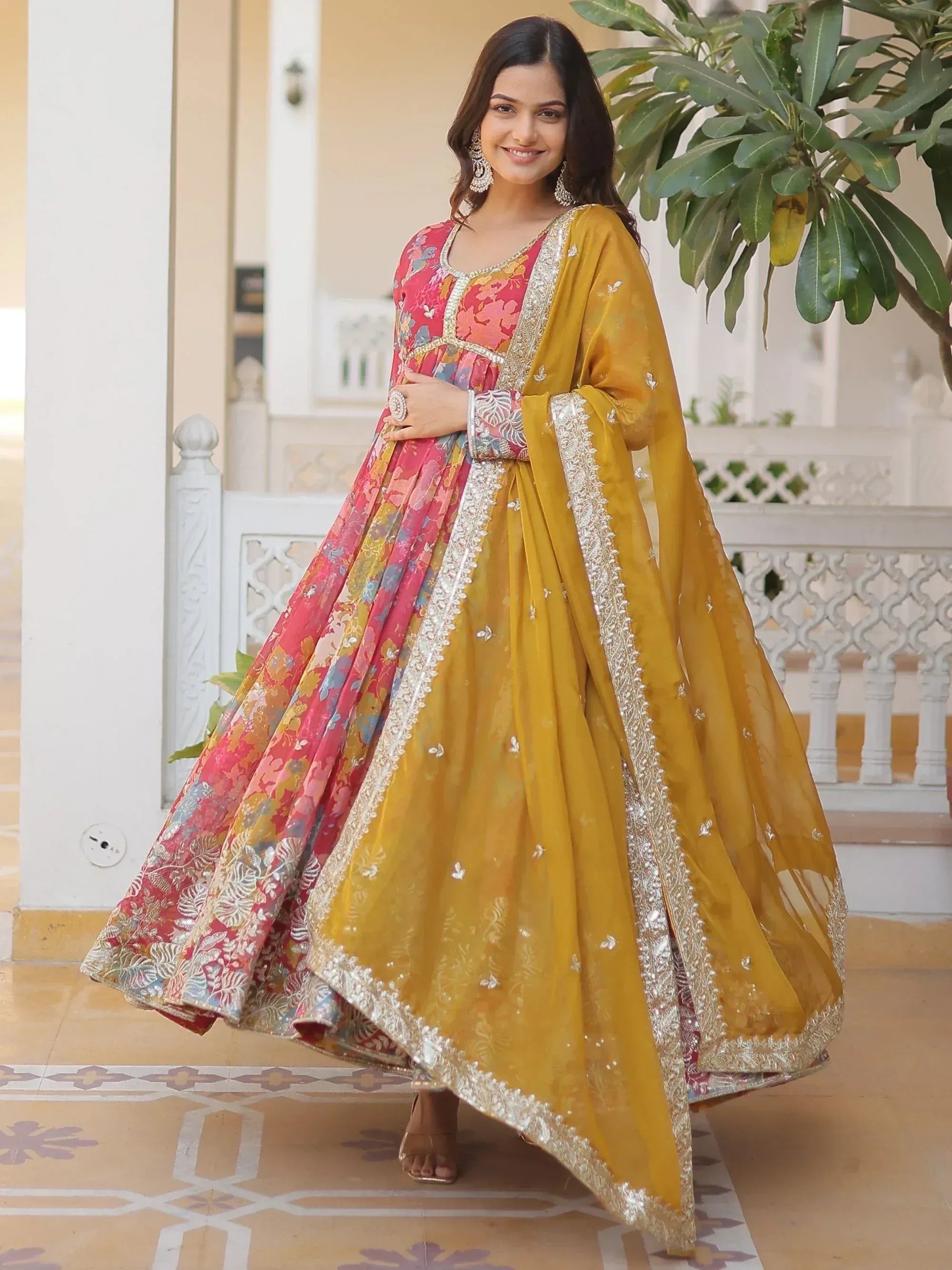Woman in vibrant floral anarkali with yellow dupatta, ethnic Indian wear for festive occasions