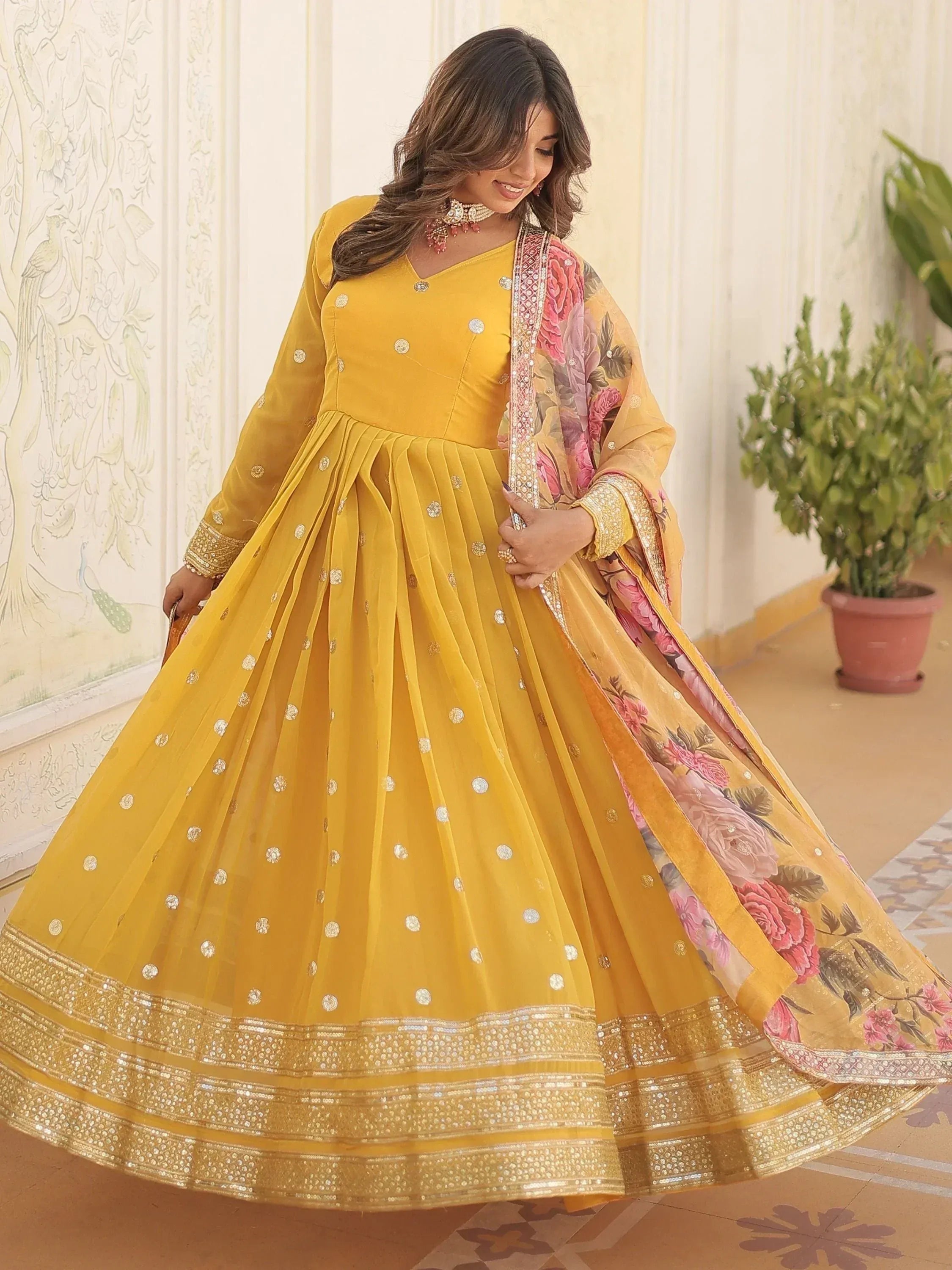 Red floral embroidered ethnic gown with gold detailing, perfect for Indian celebrations and weddings.