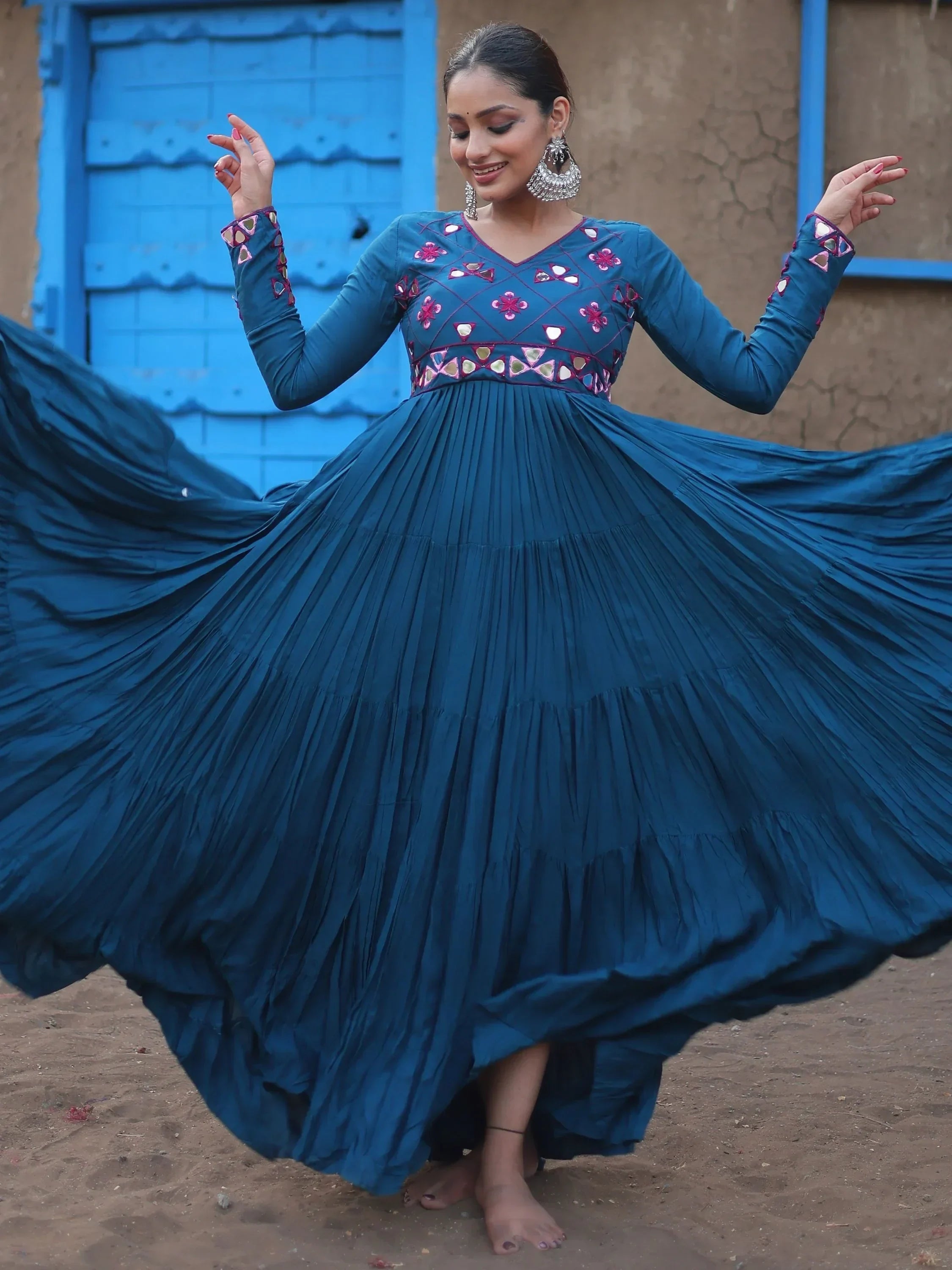 Woman in a blue embroidered ethnic gown with mirror work, posing outdoors