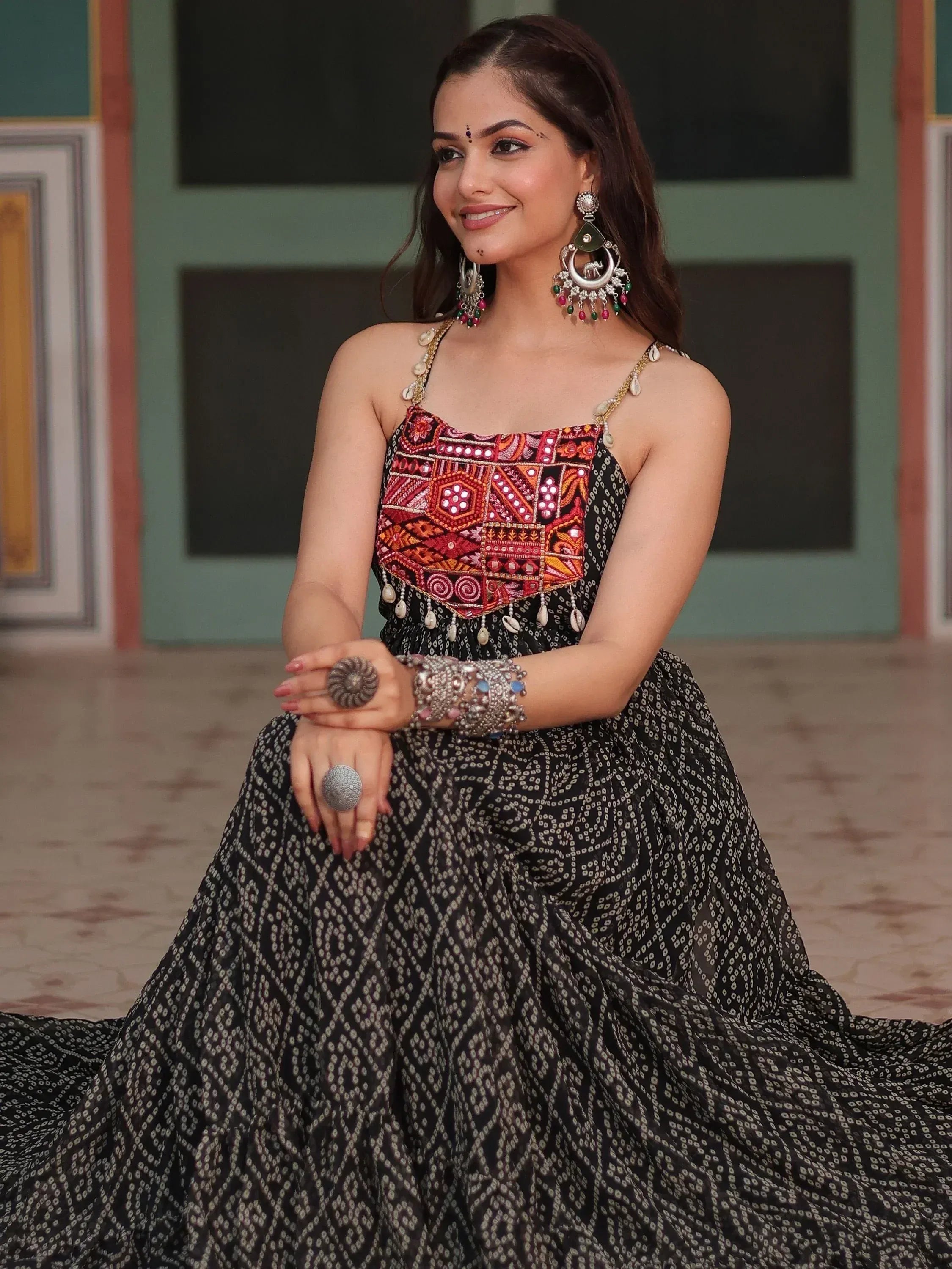 Woman in black ethnic gown with colorful embroidered bodice and traditional jewelry