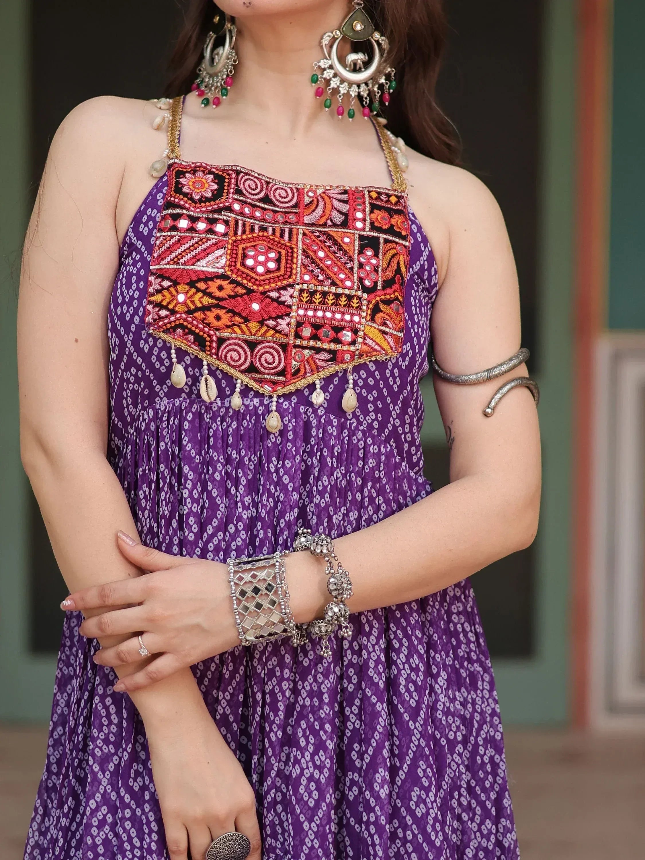 Purple ethnic gown with mirror work, embroidery, and traditional jewelry for Indian wear