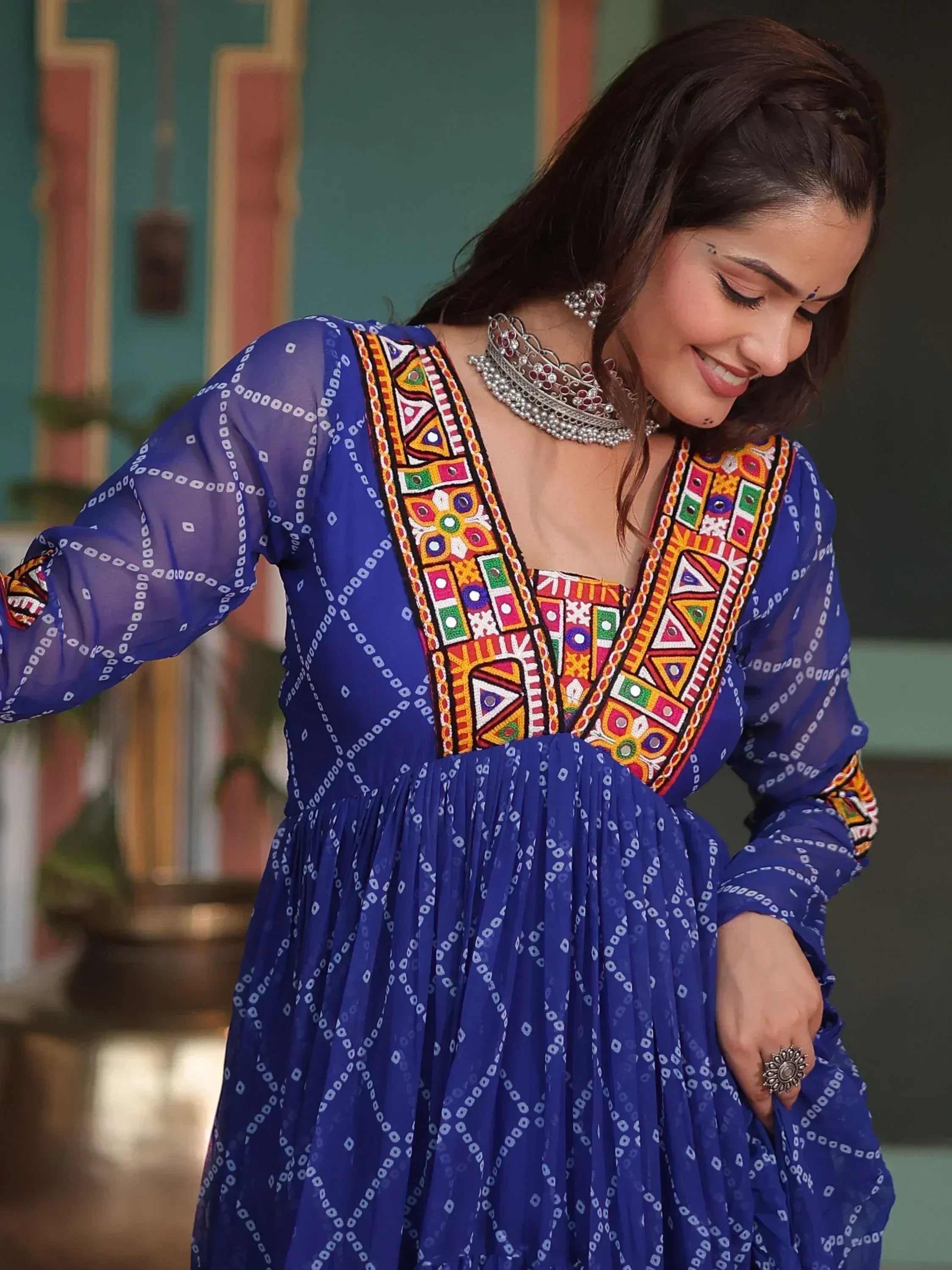 Blue ethnic gown with colorful mirror work and bandhani print, styled with traditional jewelry