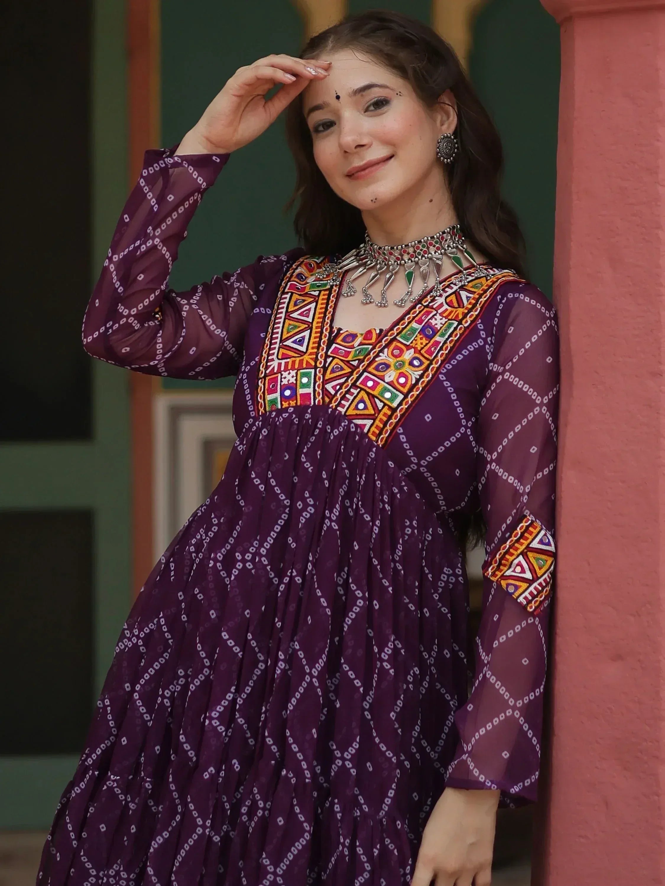 Purple ethnic gown with colorful mirror work and geometric print, styled with traditional jewelry