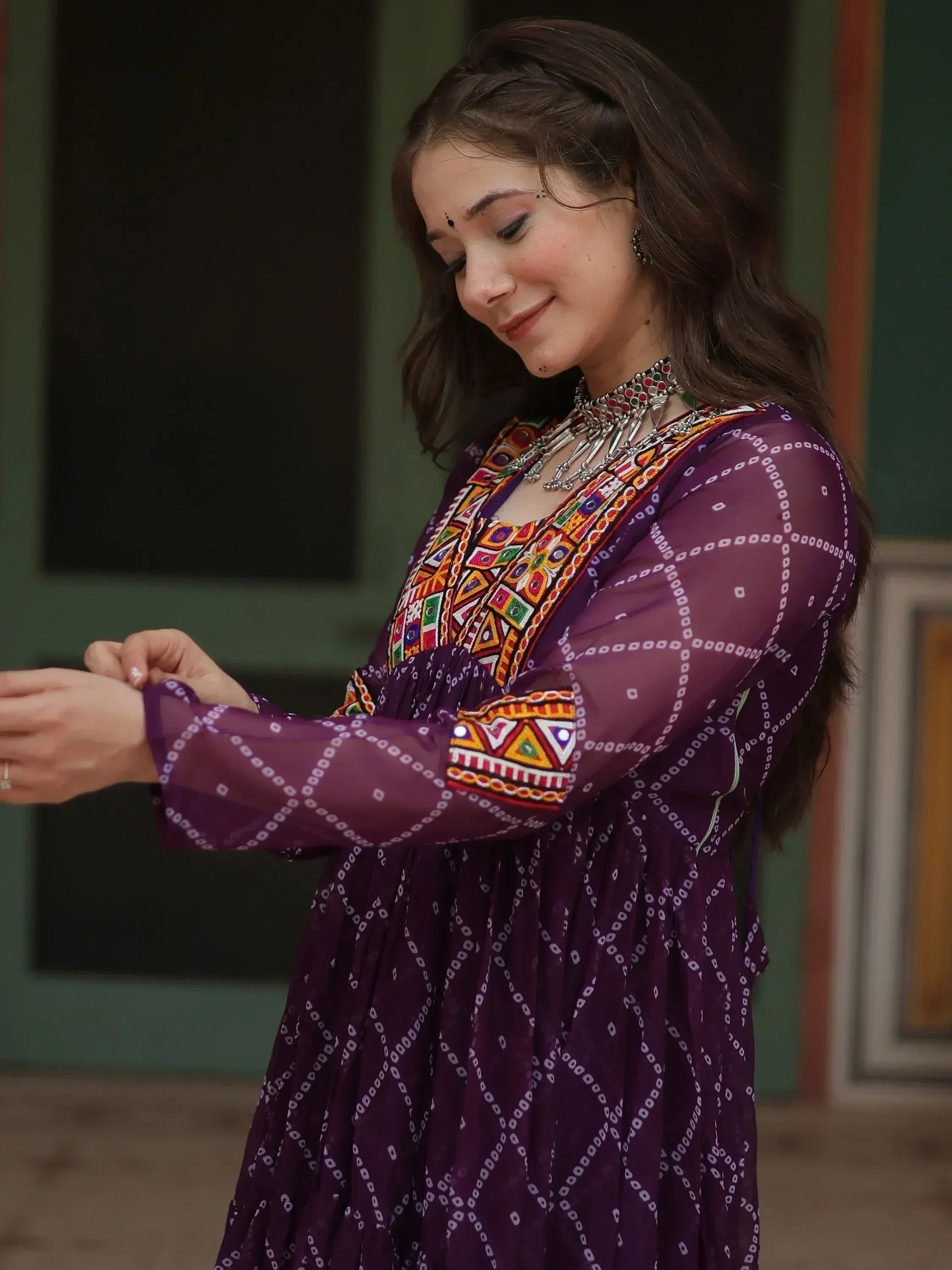 Woman in purple ethnic gown with colorful embroidery and mirror work, traditional Indian wear