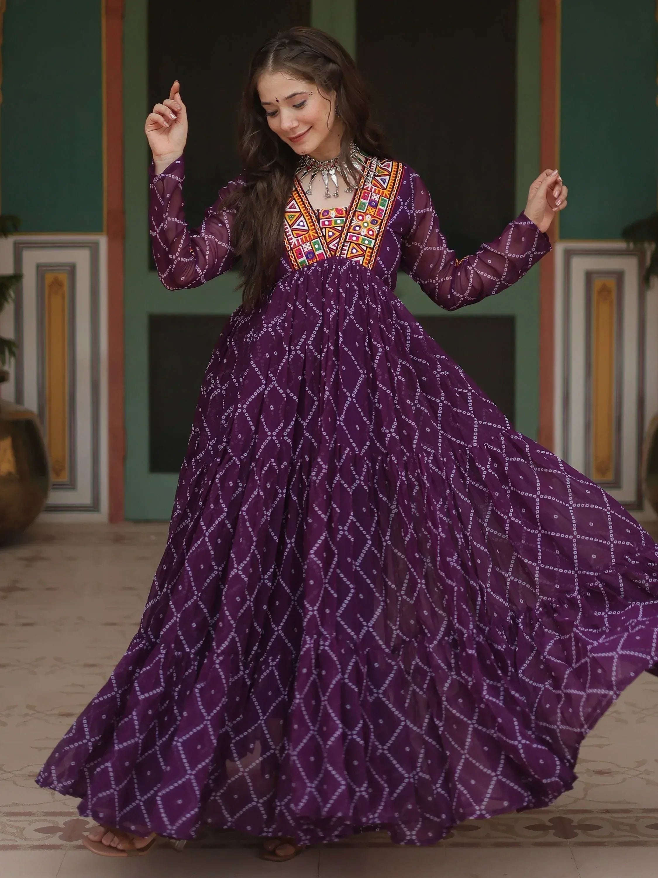 Woman in purple ethnic gown with colorful embroidery, twirling gracefully in traditional Indian attire.