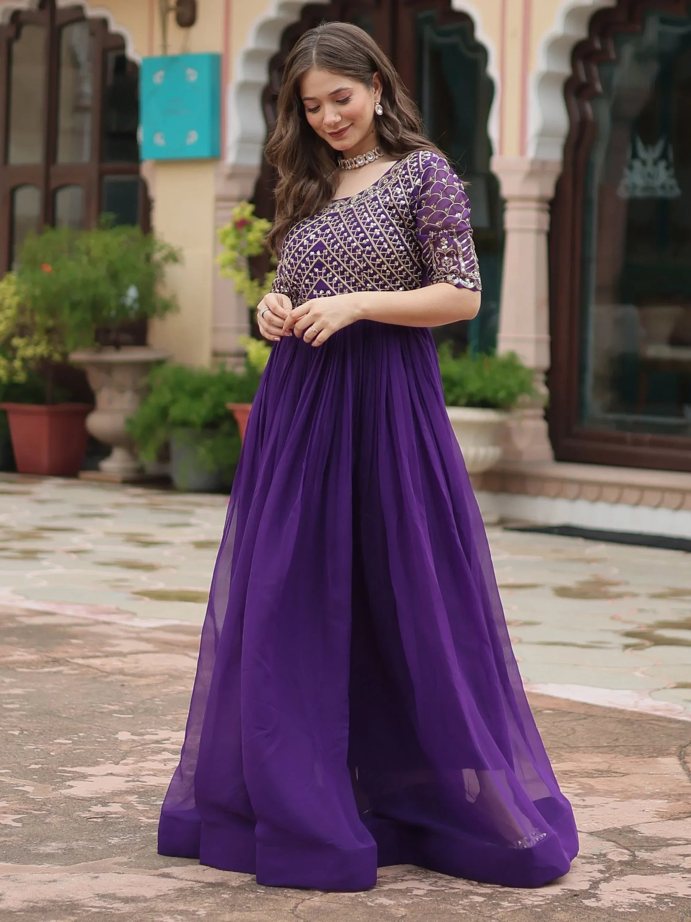 Woman wearing a purple embroidered ethnic gown outdoors, Indian festive fashion