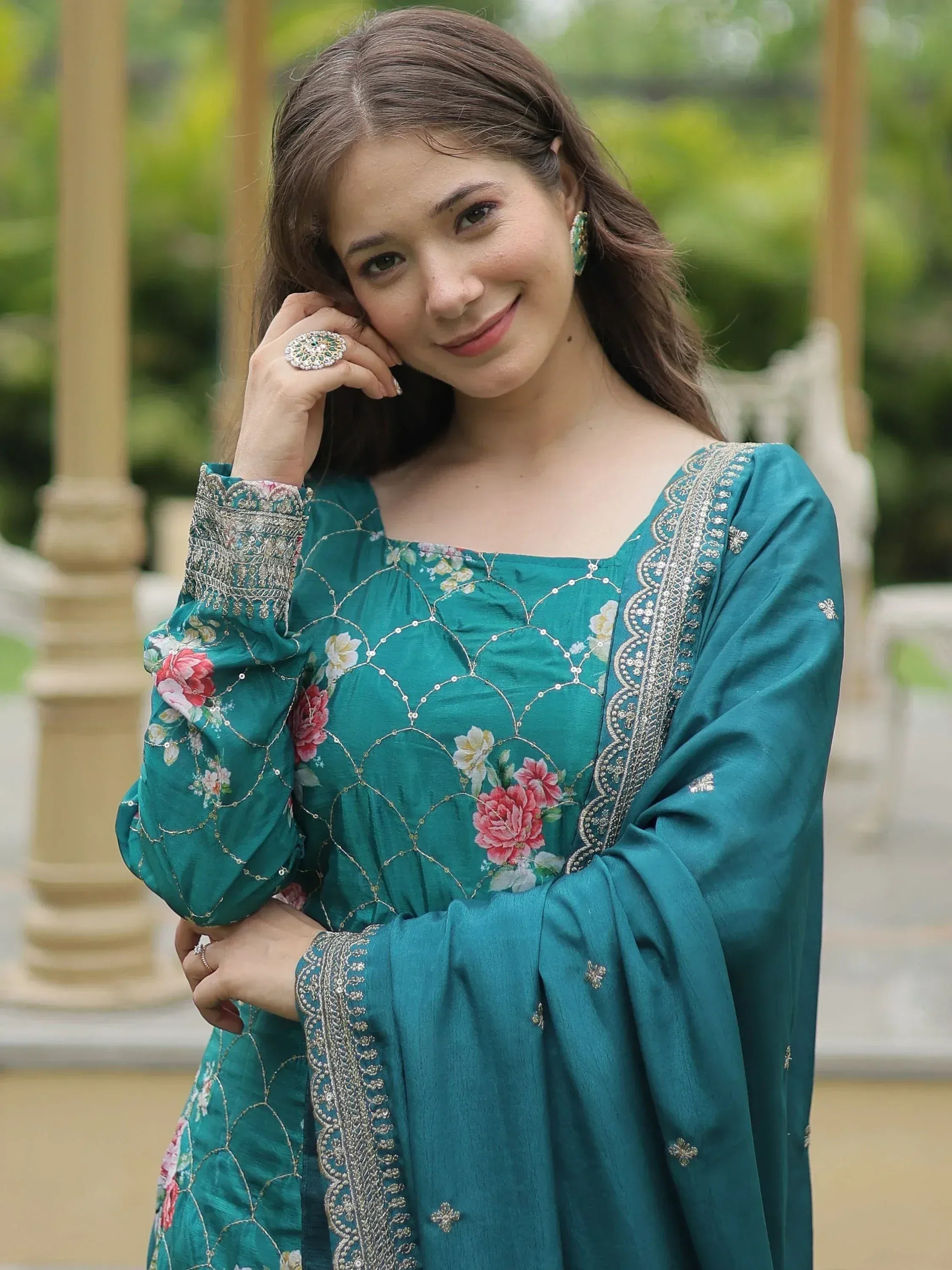 Teal floral embroidered ethnic gown with intricate gold detailing and matching jewelry