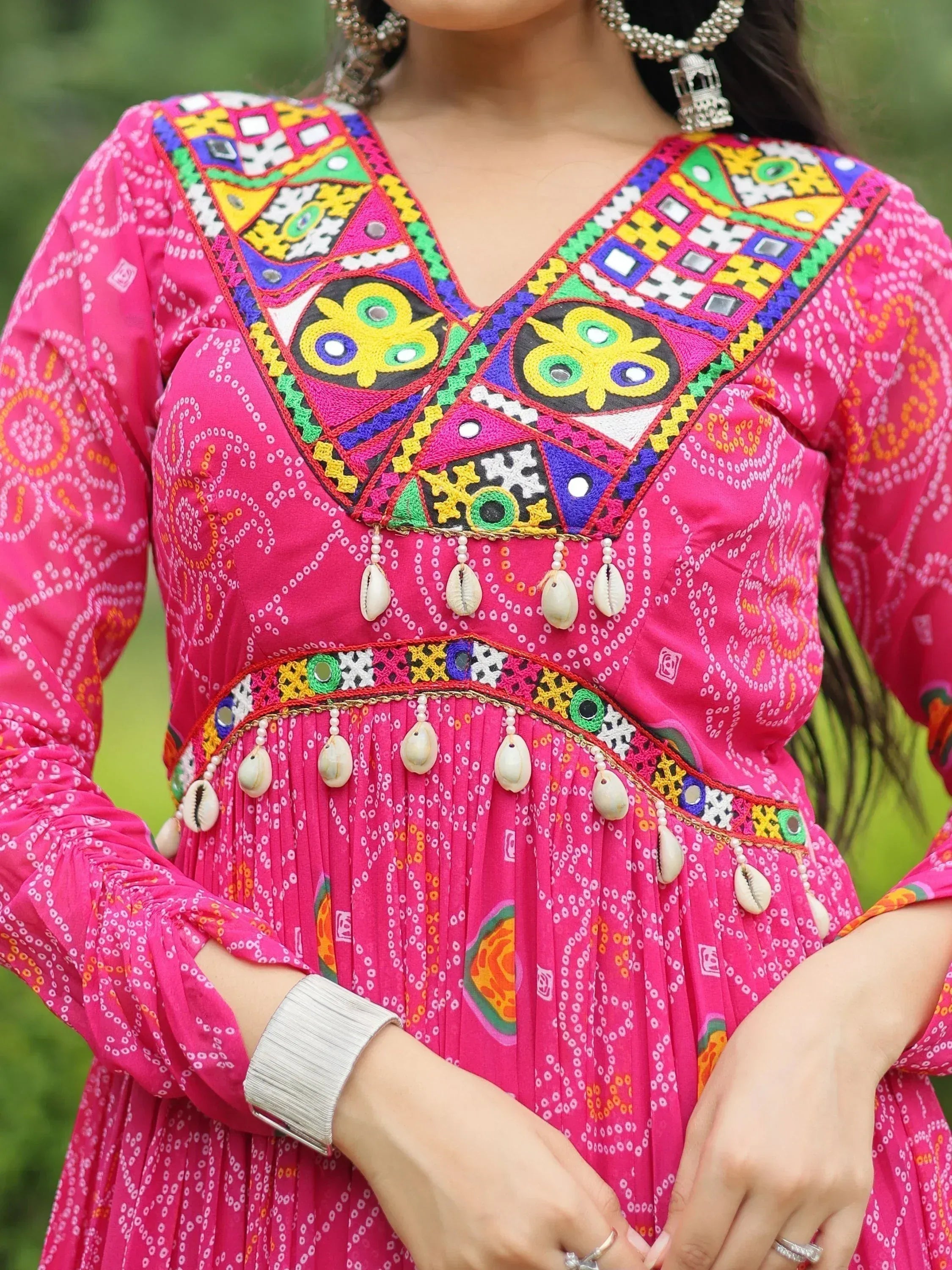 Vibrant pink ethnic gown with mirror work, embroidery, and shell embellishments for festive occasions