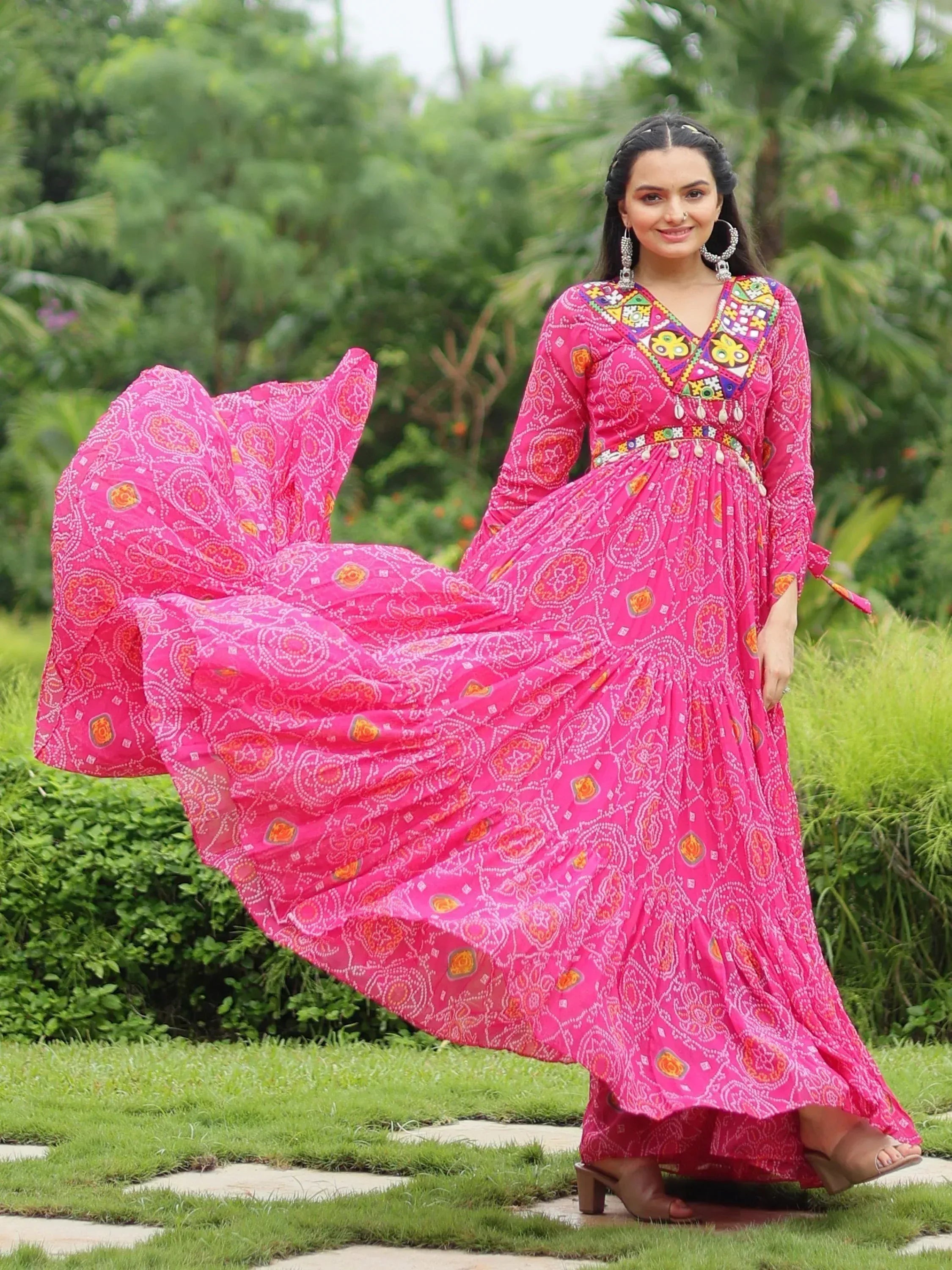 Vibrant pink ethnic gown with mirror work and printed motifs, perfect for Indian occasions