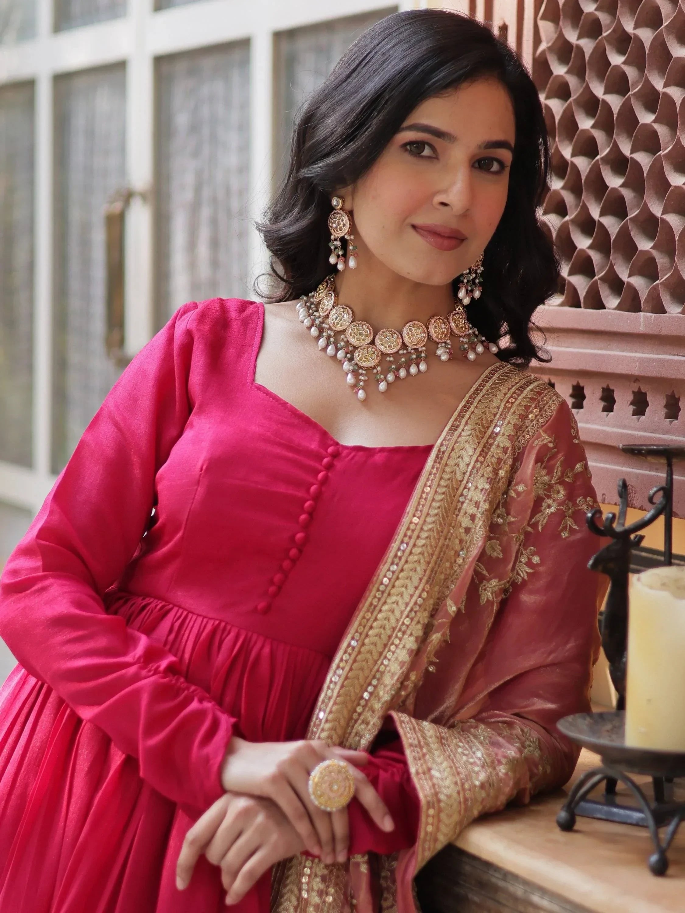 Woman in pink ethnic gown with golden embroidered dupatta and traditional jewelry