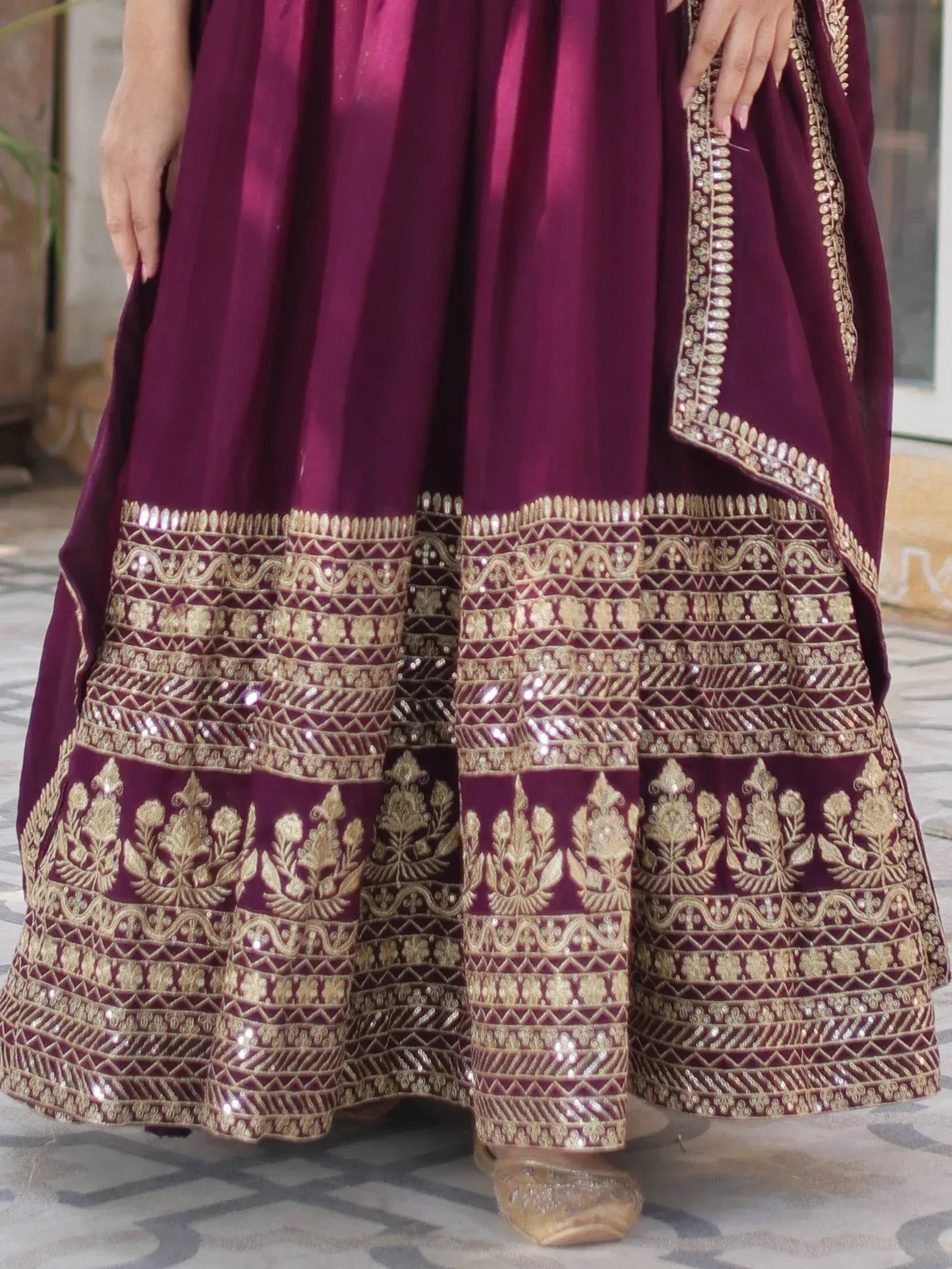 Rich maroon lehenga with intricate gold embroidery and sequin detailing, perfect for Indian ethnic wear occasions.