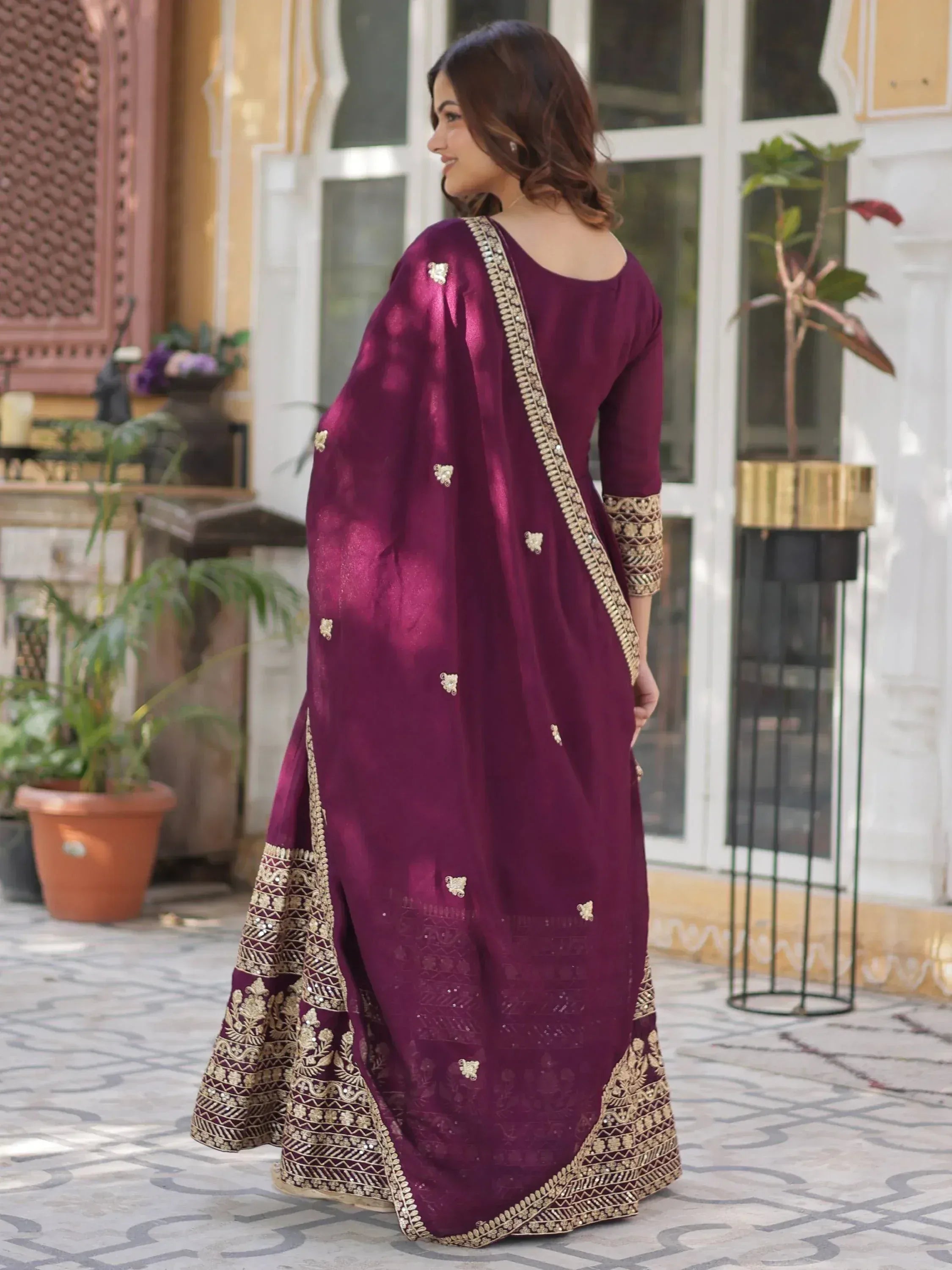Elegant maroon ethnic gown with gold embroidery, perfect for Indian occasions and festive wear.
